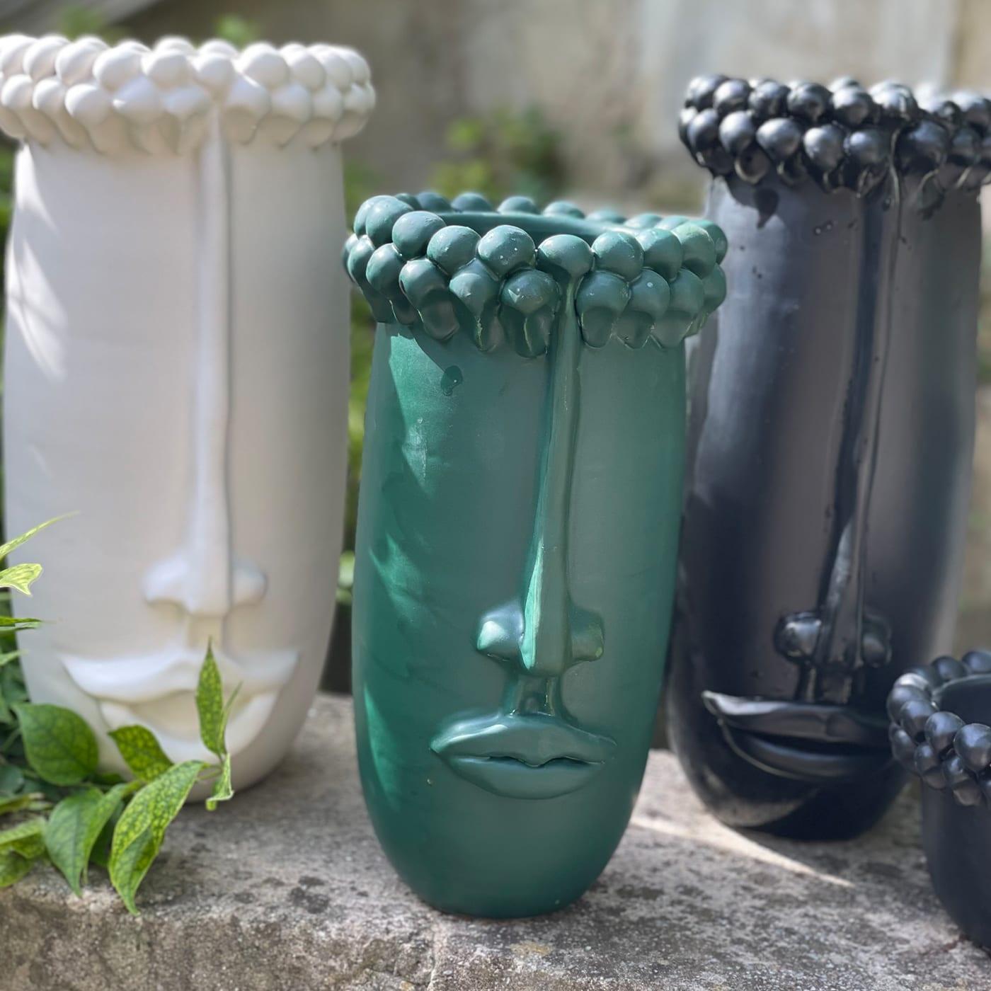 Un vase décoratif pour la maison, qui peut contenir de l'eau et des fleurs. Les pommes de pin au-dessus de la tête sont un élément qui caractérise la culture sicilienne : un symbole d'hospitalité et de bons vœux.