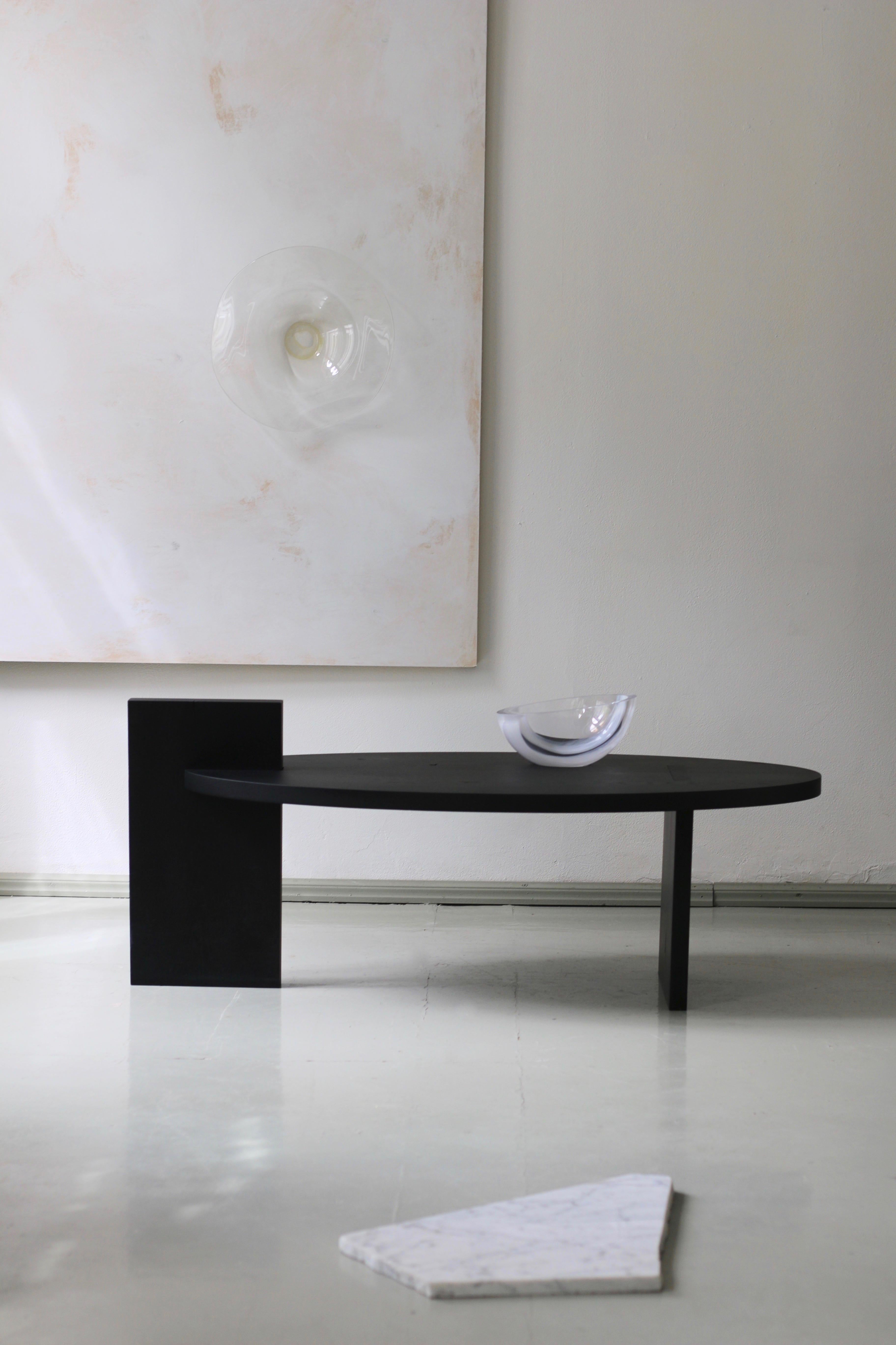 'Black Lotus' contemporary minimalist coffee table is defined as ‘art with function’. It consists of only three pieces that are held together by interlocking geometrical cuts without additional bracing. 
Hand-picked solid oak slabs with natural wood