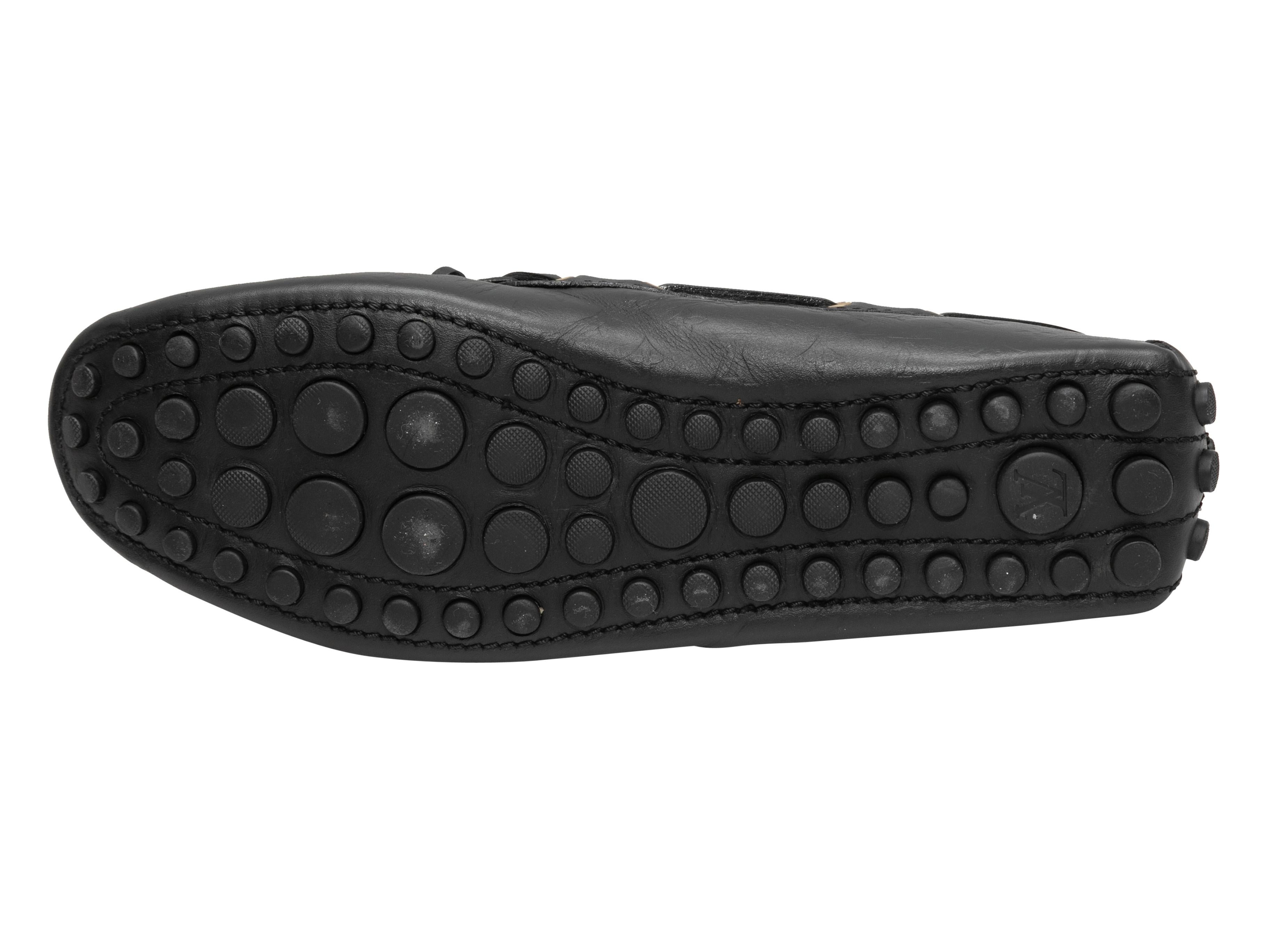 Mocassins en cuir monogrammé embossé noir de Louis Vuitton. Butoirs en caoutchouc au niveau des semelles et des contreforts. Des nœuds sont placés sur le dessus.