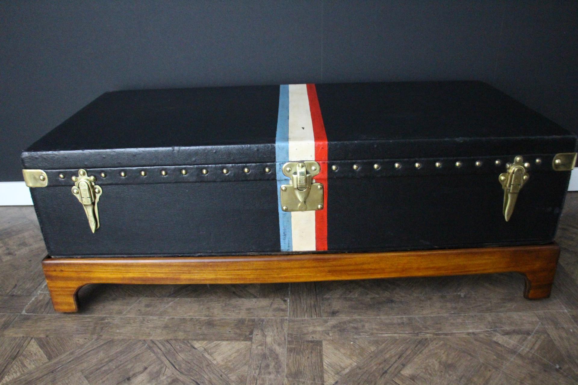 Este bonito baúl grande Louis Vuitton de lona negra, con cerraduras y tachuelas de latón macizo estampado Louis Vuitton y asas laterales de cuero y latón, lleva rayas pintadas personalizadas para darle un toque extra de personalidad.
Su interior es