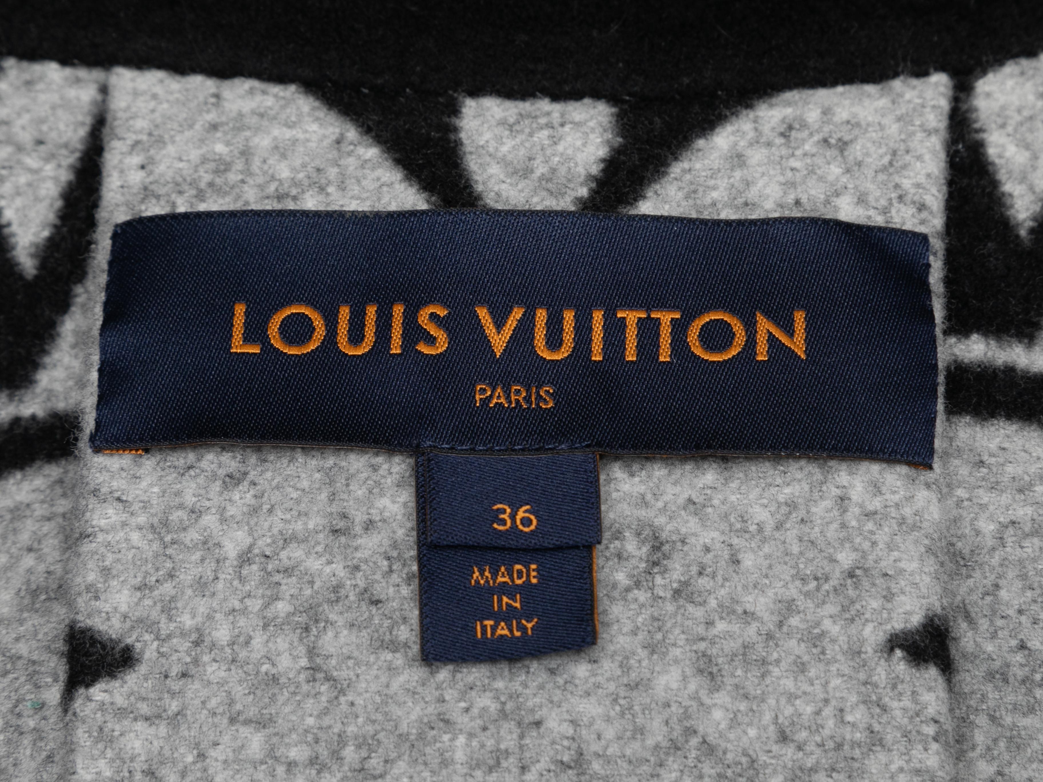 Black wool cape by Louis Vuitton. Logo coated canvas accent at neckline. Front closure. 36