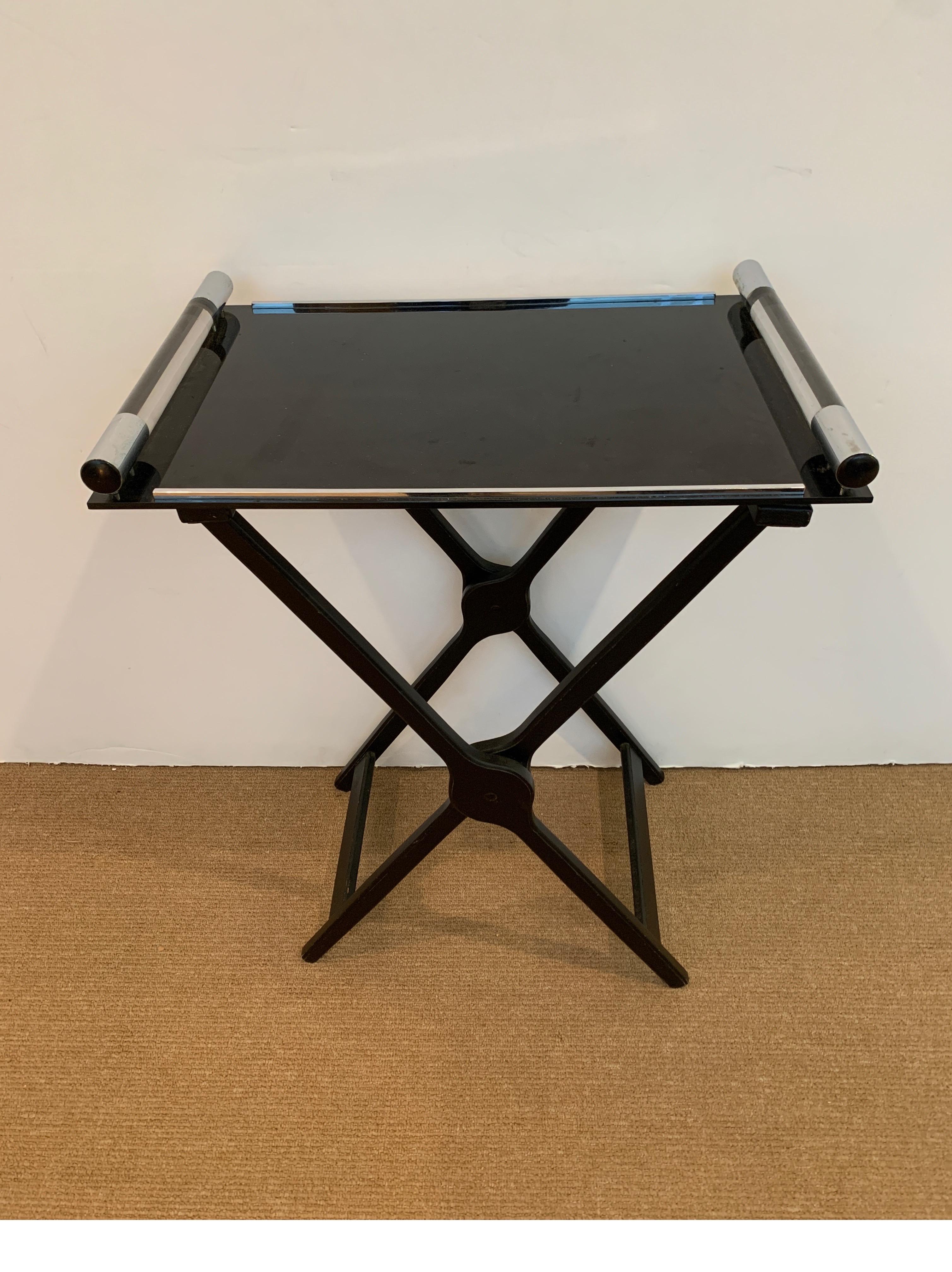 Chic and modern 1970s tray on stand. The ebonized wood X-base with black Lucite tray top with clear Lucite handles.
Dimensions: D16