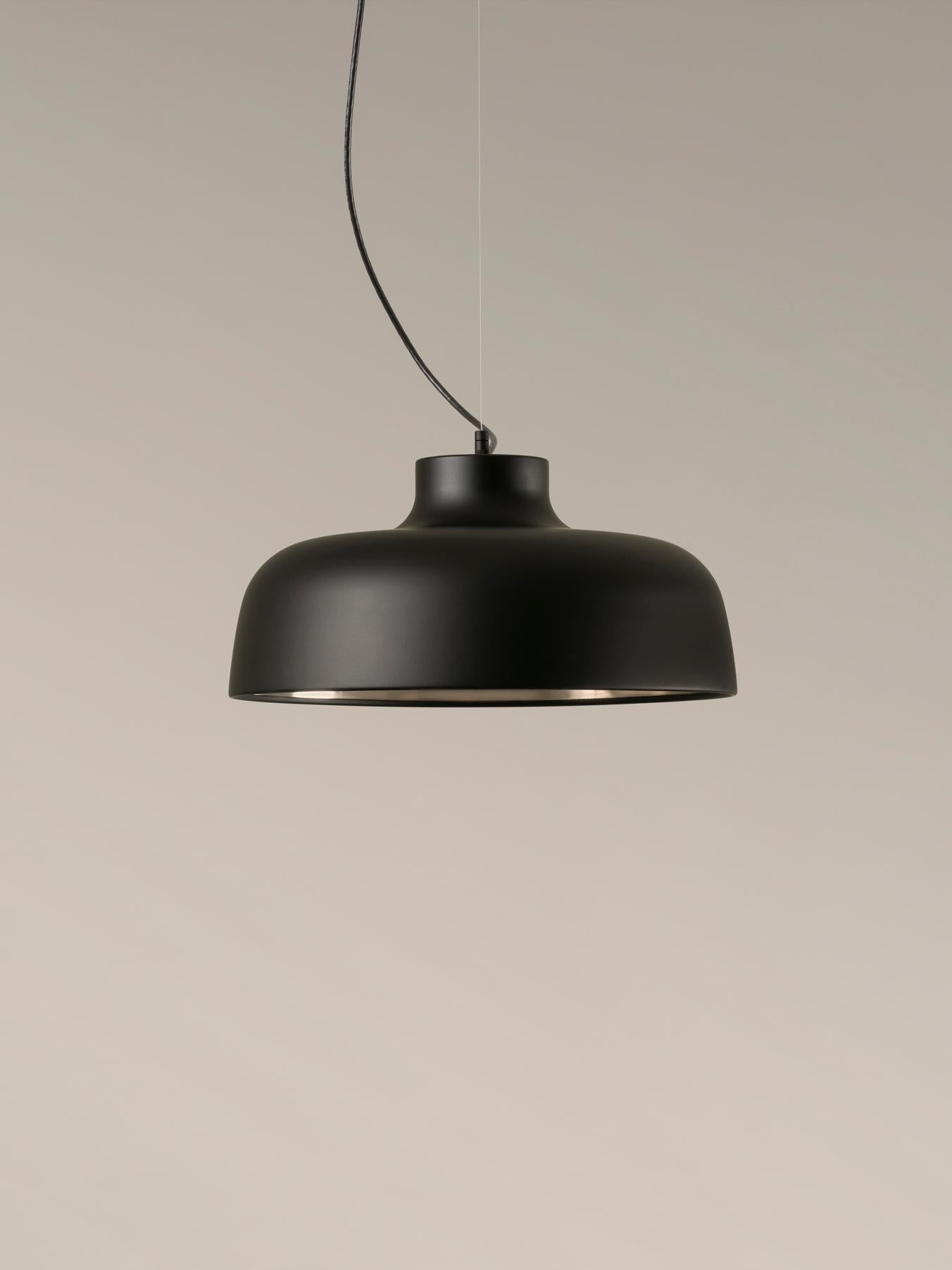 Black M68 pendant lamp by Miguel Milá
Dimensions: D 46 x H 22 cm
Materials: Aluminum.
Available in other colors.

The redolent shades of M68, in vibrant red, white or matt black, as well as polished aluminium, were inspired by the shape of a