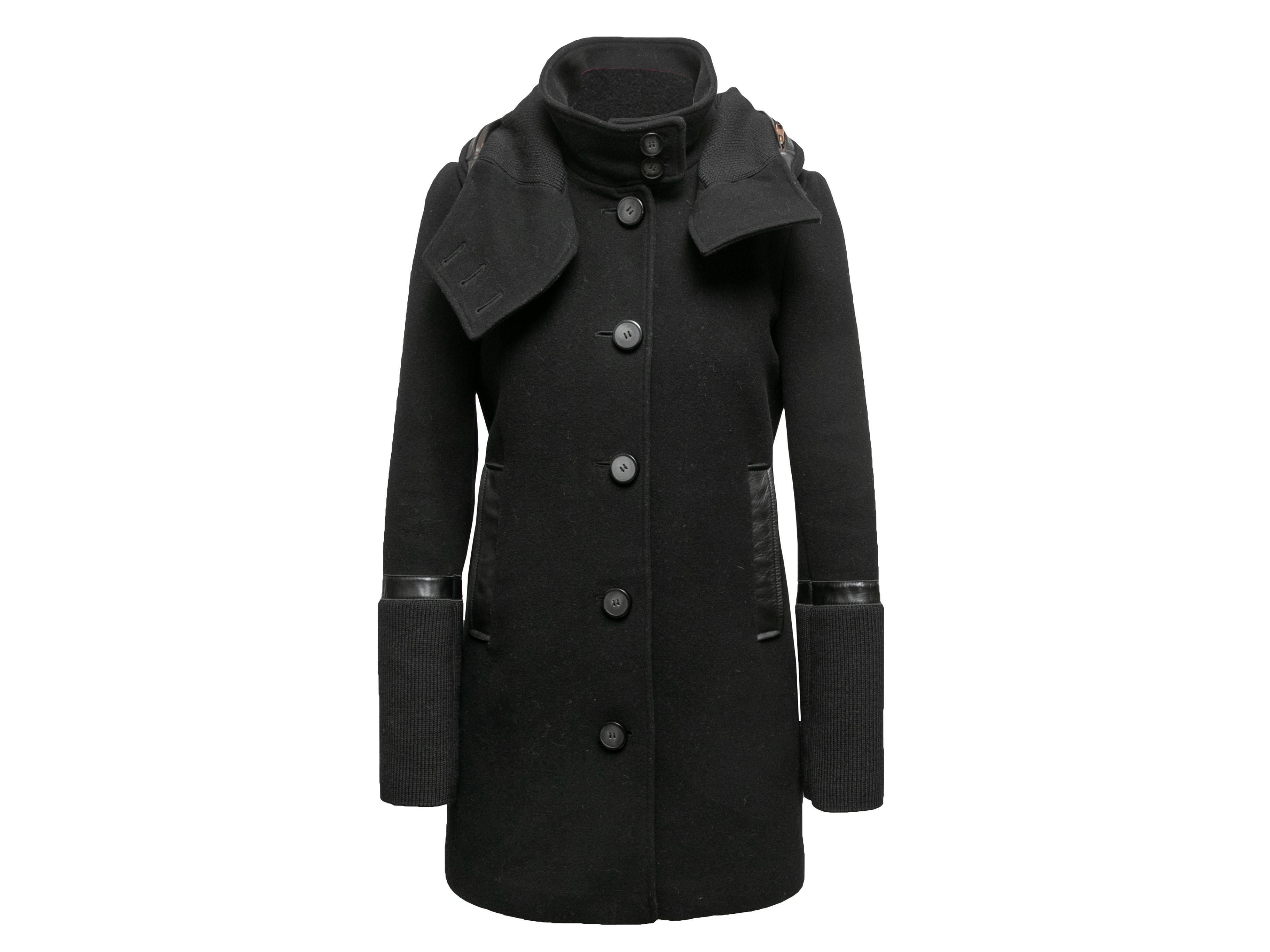 Cappotto in lana nera bordato in pelle di Mackage. Colletto a cavalletto. Doppie tasche sui fianchi. Polsini a costine. Chiusura con bottoni al centro davanti. Busto di 35 cm, larghezza delle spalle di 15 cm, lunghezza delle maniche di 25 cm,