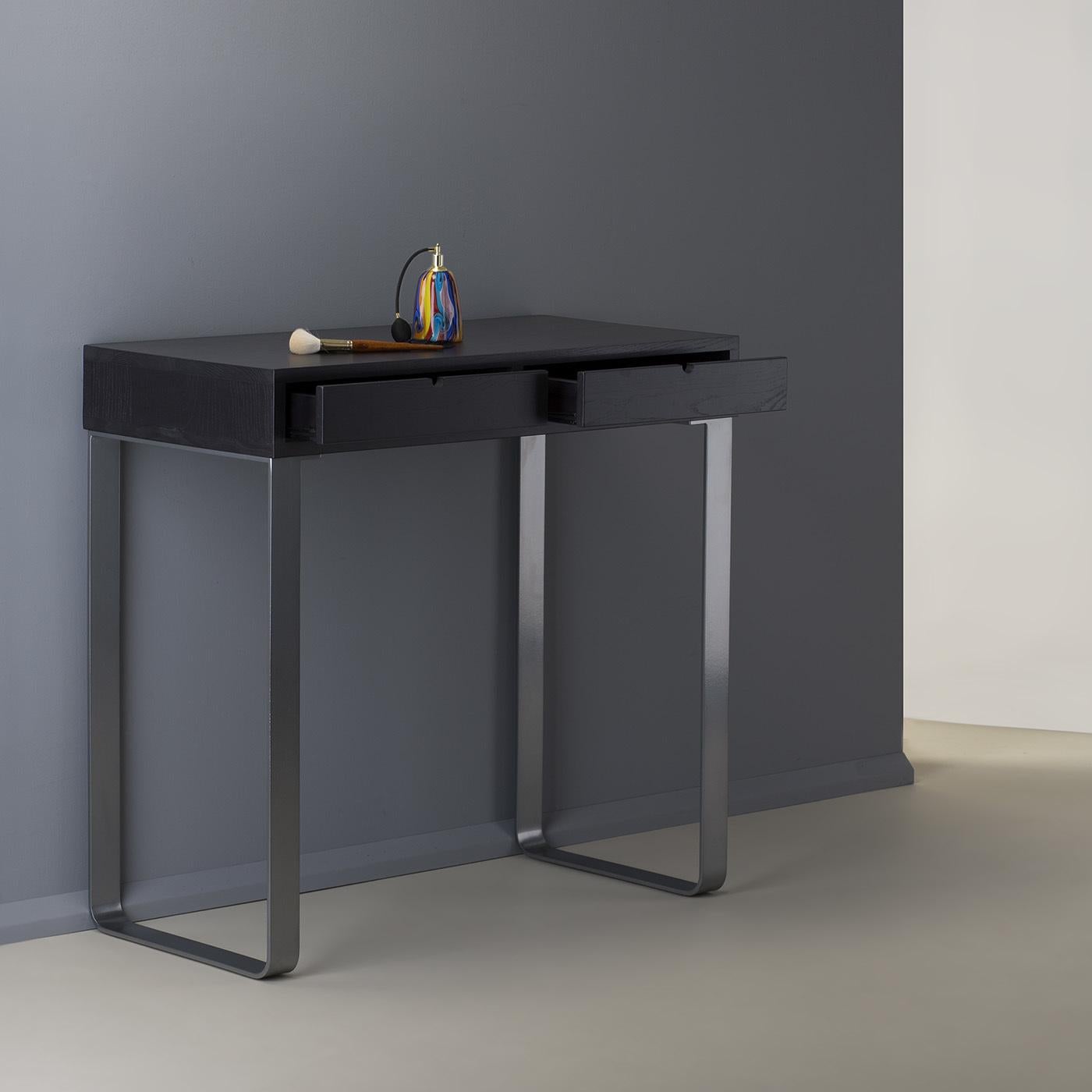 Designed with essential and simple lines to match all of Unica's luxury mirrors, this vanity desk features a black-varnished structure with a rectangular ash wood top supported by two, U-shaped silver aluminum legs. The two front drawers provide