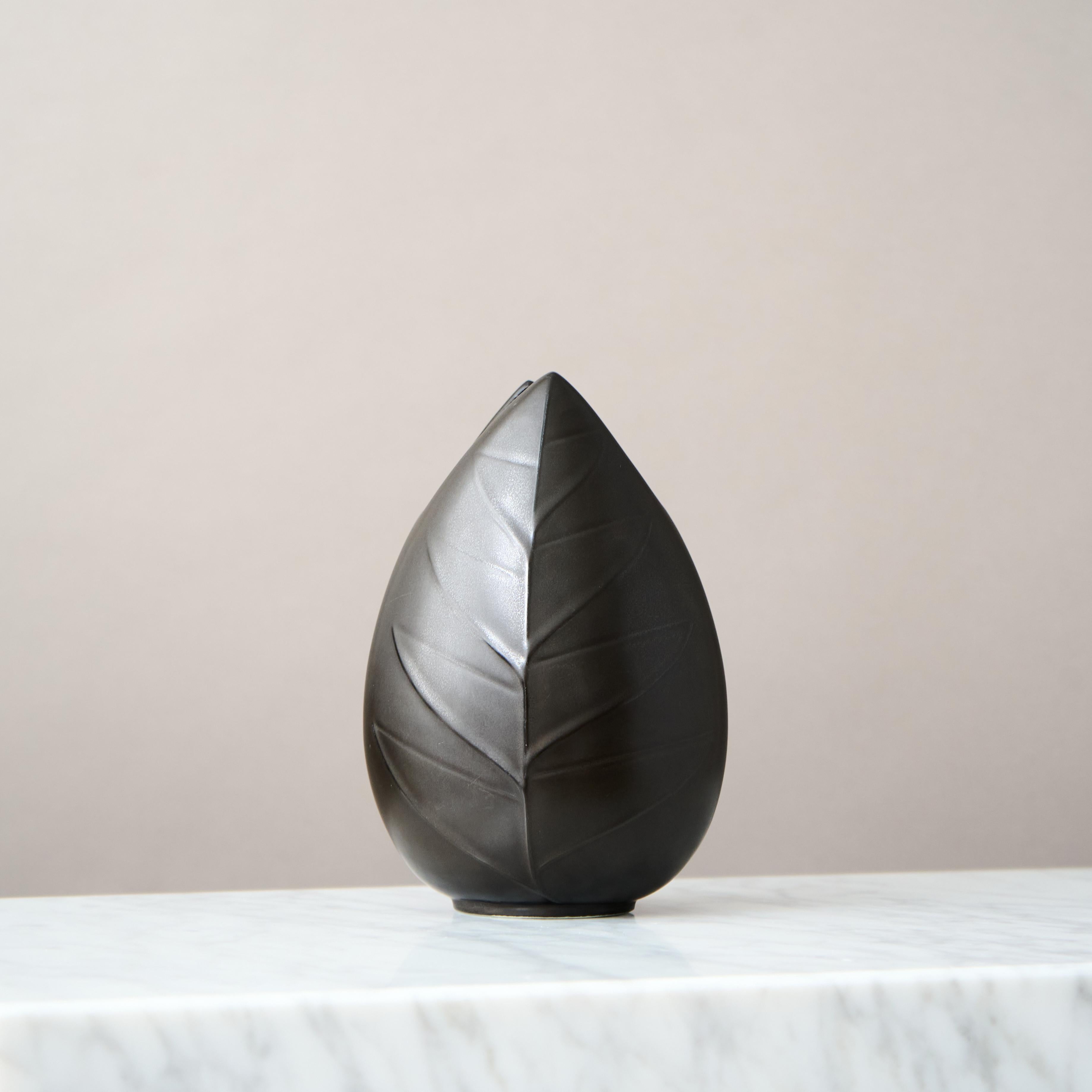 Un magnifique vase en forme de feuille avec une étonnante glaçure noire, mate, 'Mangania'.
Conçu en 1955 par Lillemor Mannerheim pour la manufacture de porcelaine de Gefle en Suède.

Excellent état. 
Estampillé avec la marque du fabricant.

Lillemor