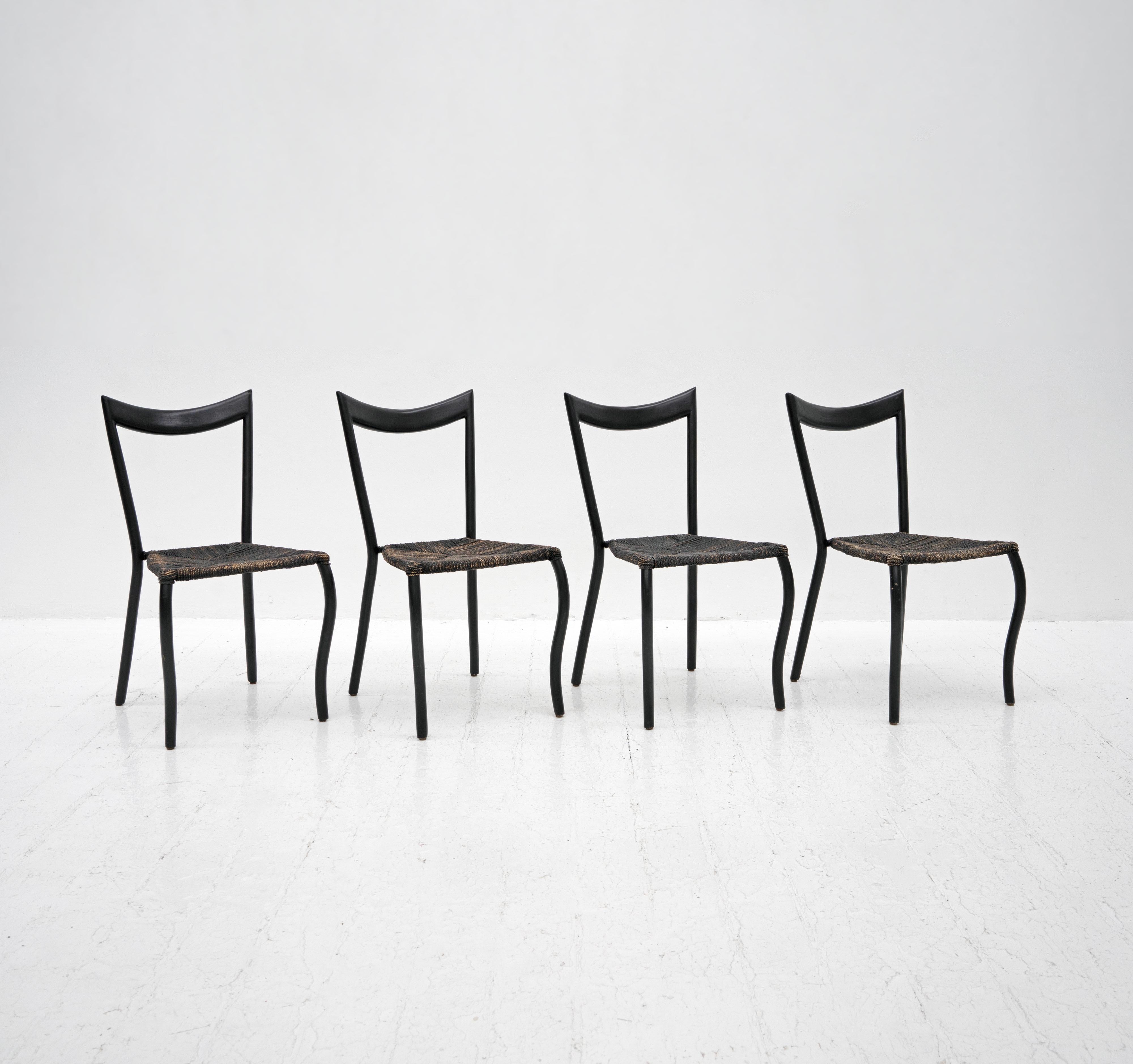A set of 4 'Manila' dining chairs designed by Val Padilla and retailed by Conran in the 1980's. Composed from black lacquered wooden frames and woven, stained seagrass seats. 

Dimensions (cm, approx):
Height: 89
Width: 53
Depth: 57
