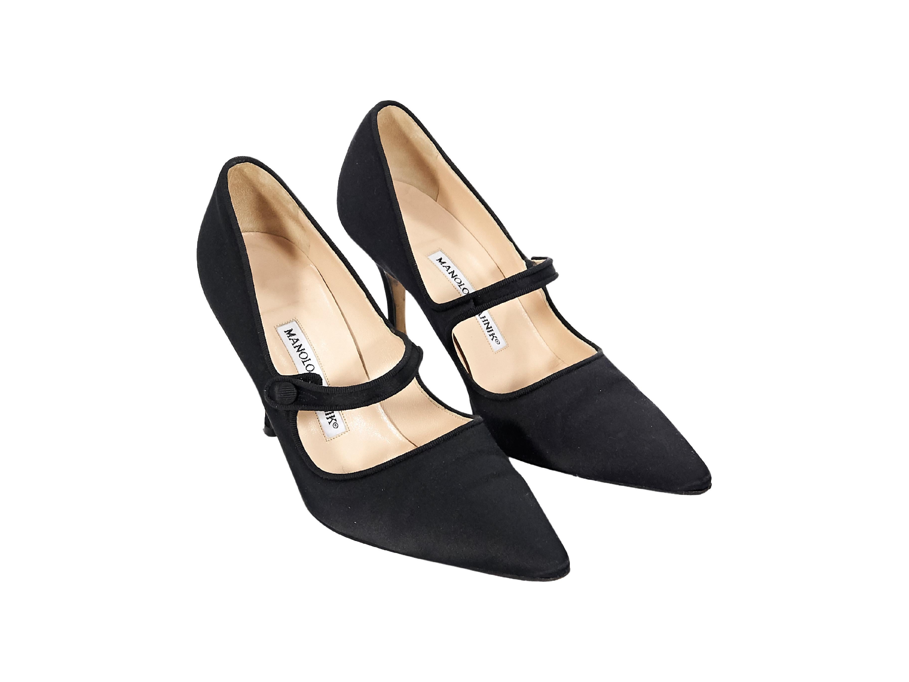 Product details:  Black satin Mary Jane pumps by Manolo Blahnik.  Instep strap closure.  Point toe.  3.75