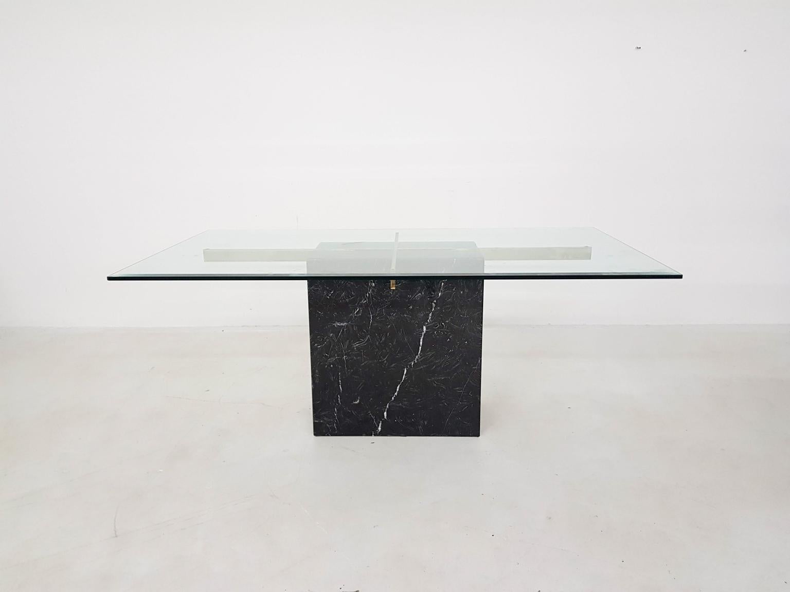 Black marble dining table with brass details which holds the glass top.

The glass top has a scratch on the top.