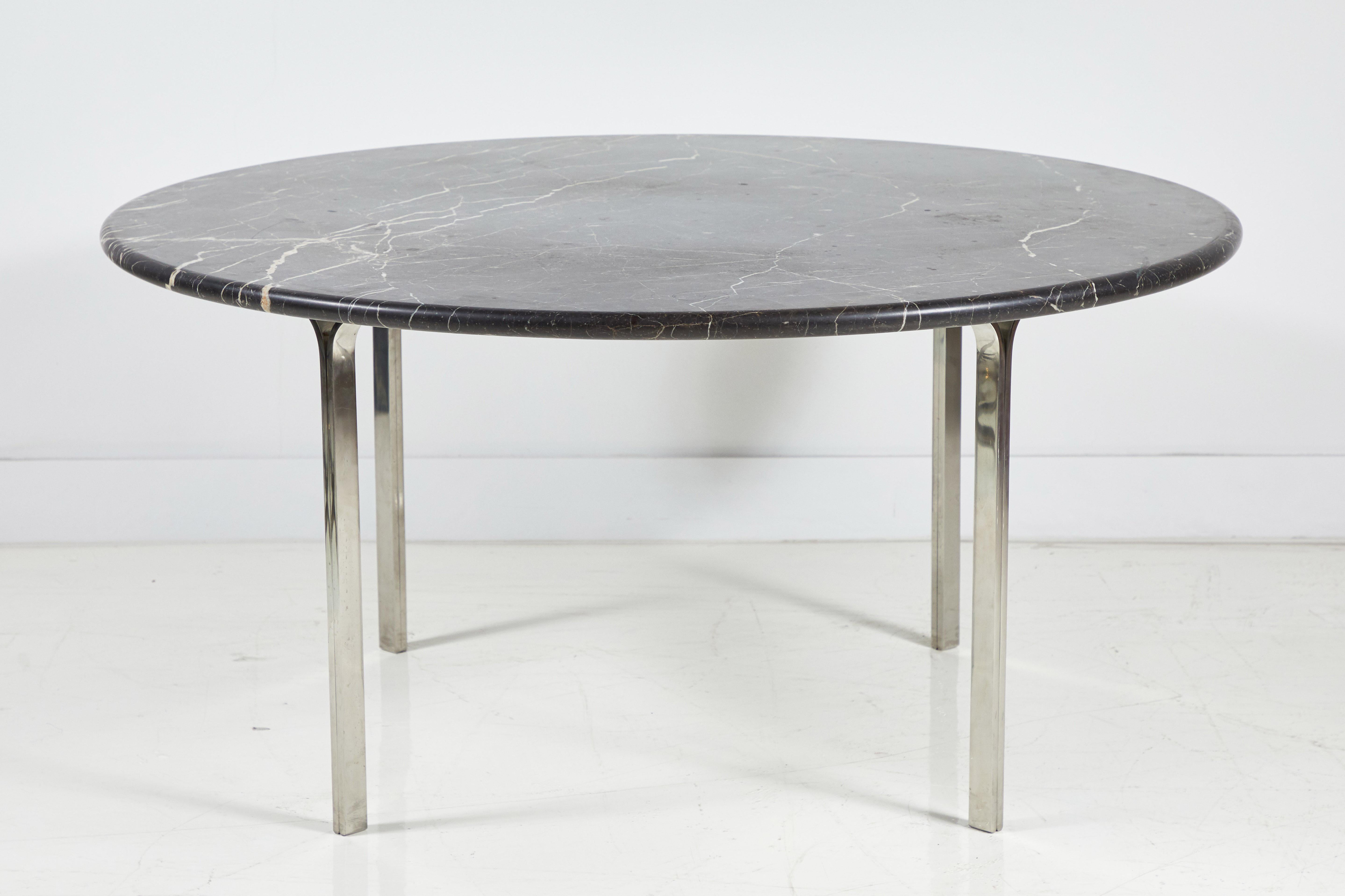Round chrome dining table with heavy black marble top.