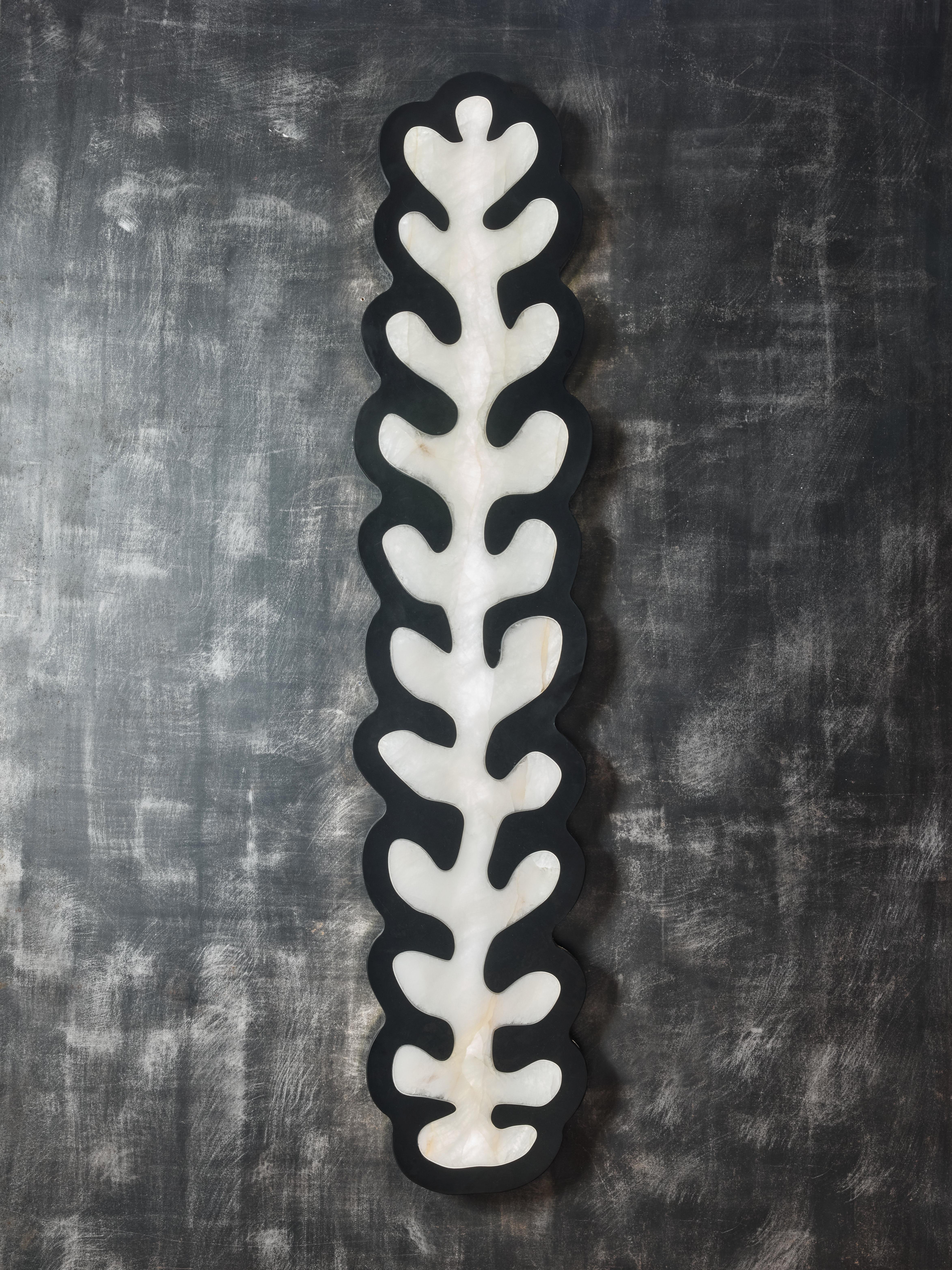 Tall wall sconces crafted from rock crystal, elegantly shaped like leaves and bordered with black Belgian marble. The illumination is provided by LEDs discreetly placed behind the rock crystal, along with a strip that encircles the piece, ensuring