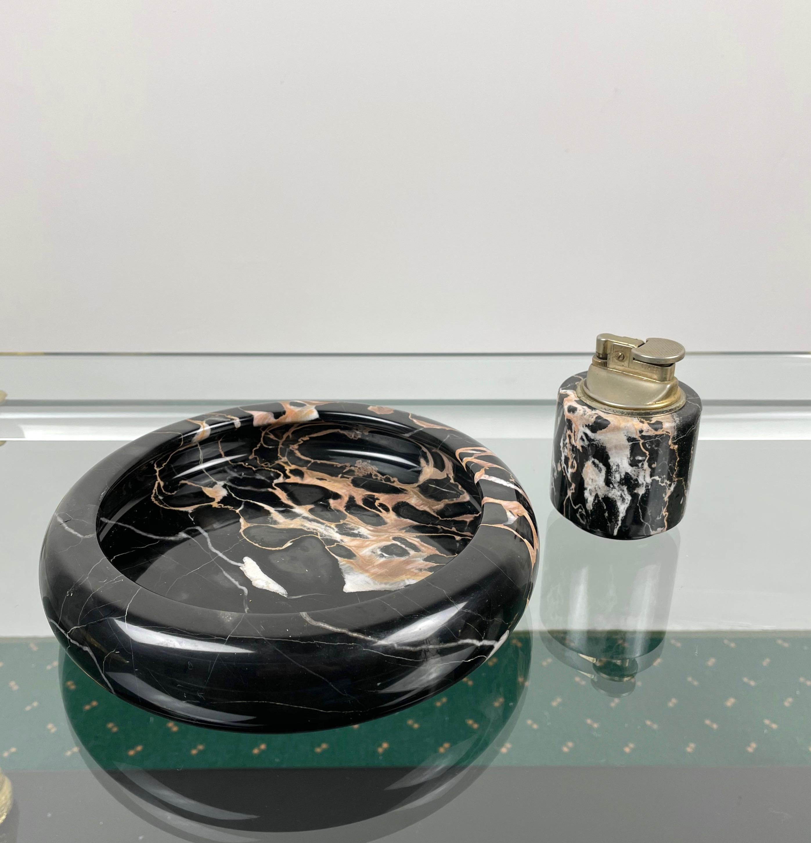 Tobacco set composed of ashtray and table lighter in black marble. Made in Italy in the 1960s. 

Dimensions:
Ashtray 20 cm D x 4 cm H.

Lighter 6 cm D x 8 cm H.

 
