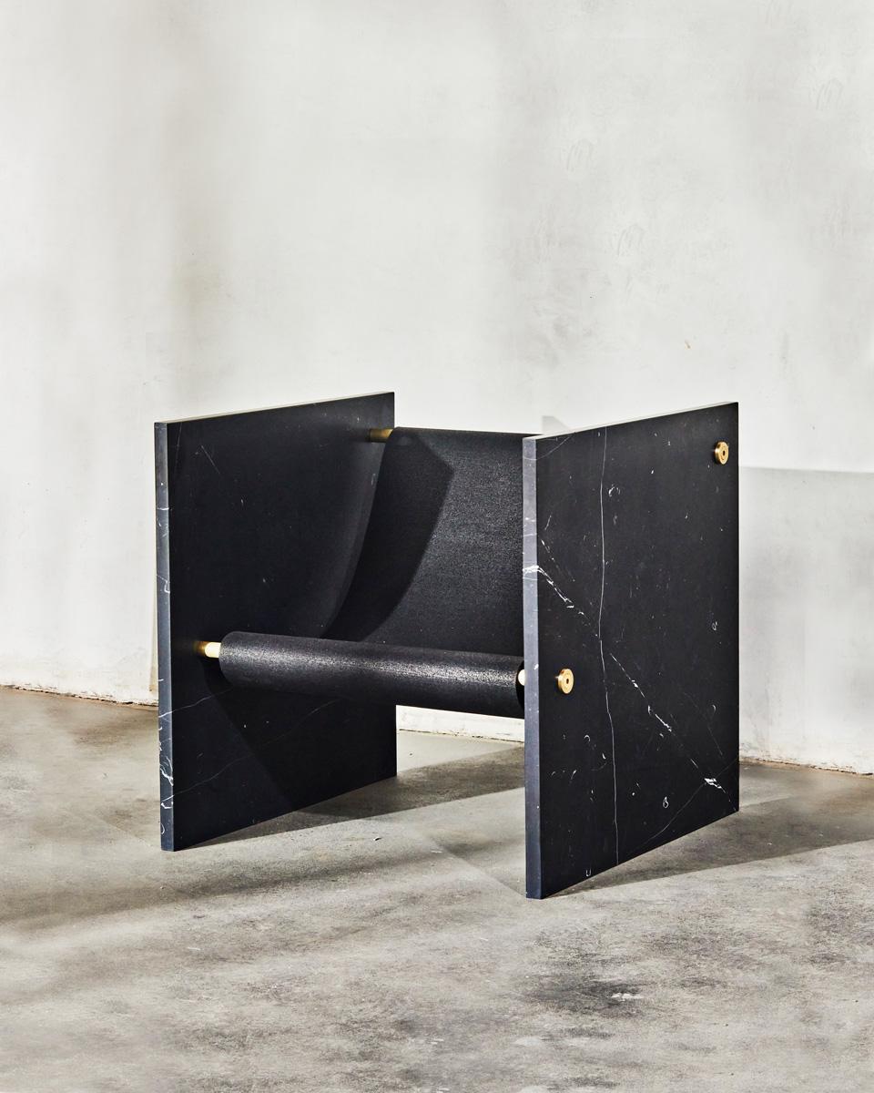 La chaise ADRI est une interprétation unique d'une chaise d'apparat qui associe des matériaux intemporels d'une manière nouvelle. La chaise est fabriquée à l'aide de deux plaques de marbre, reliées par des ferrures en laiton et des détails élégants