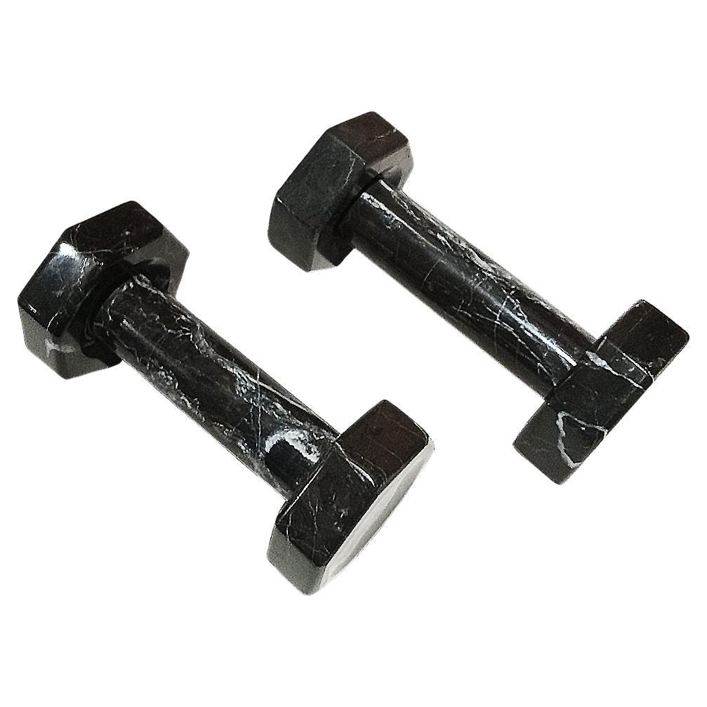 A pair of exercise dumbbells, handcrafted in smooth, polished black marble. 
Small white inclusions throughout the stone. At approximately 5 lbs. each, they can actually be used for exercising, in a very elegant way to workout. They also make