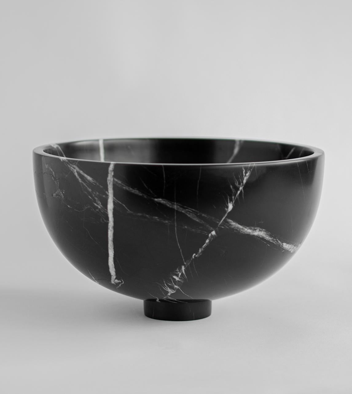 A substantial black marble bowl with unique white veining rests atop a mini pedestal for a grand presentation of fruits and vegetables. It is truly an eyecatcher in your dining room. 

There may be natural variations that are not product flaws,