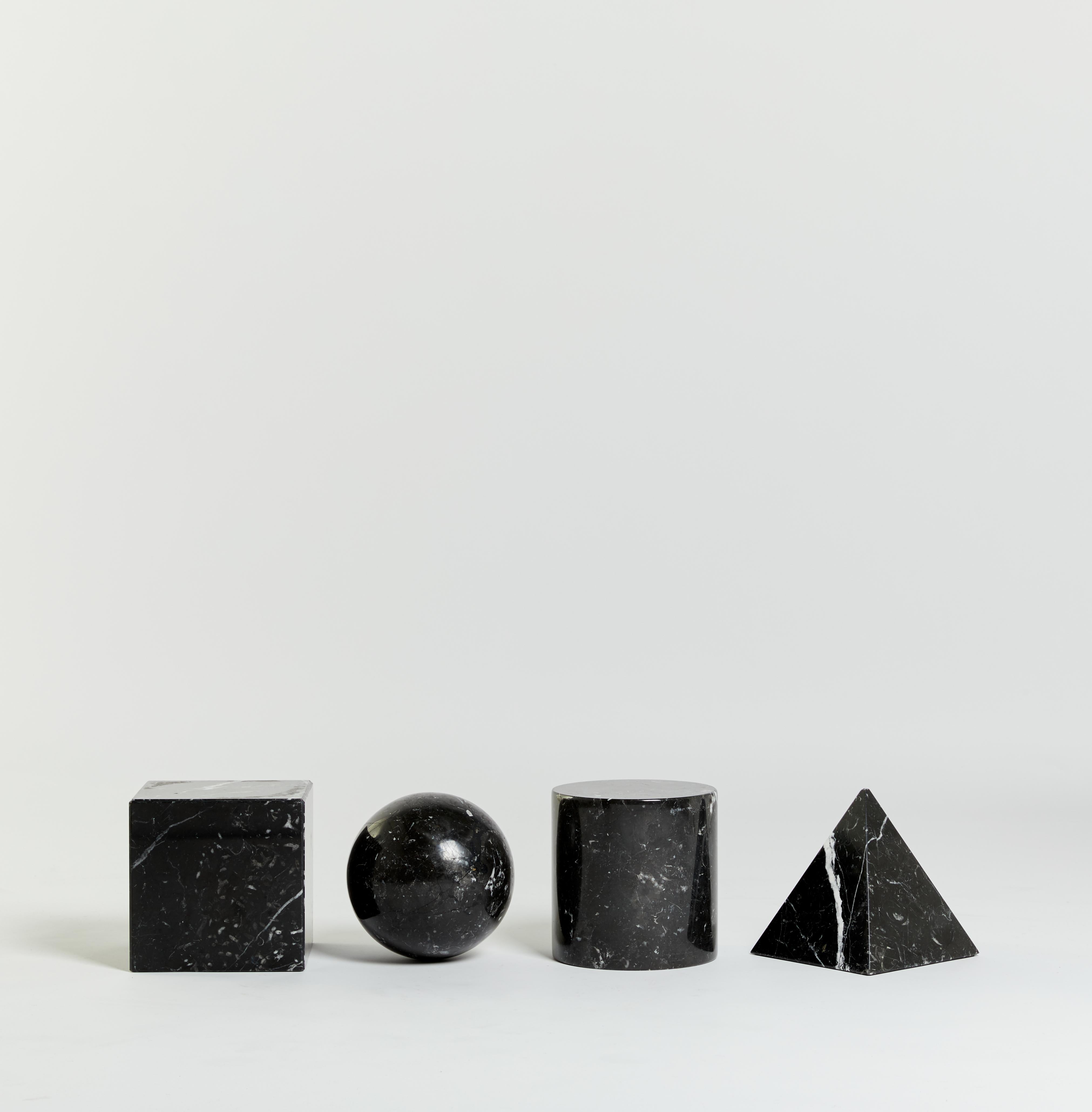 'Metafora' table by Lella and Massimo Vignelli.

Made in Italy in the late 1970s and inspired by the four forms of Euclidean geometry: the cube, the pyramid, the cylinder and the sphere. These forms are made out of black marble and can be
