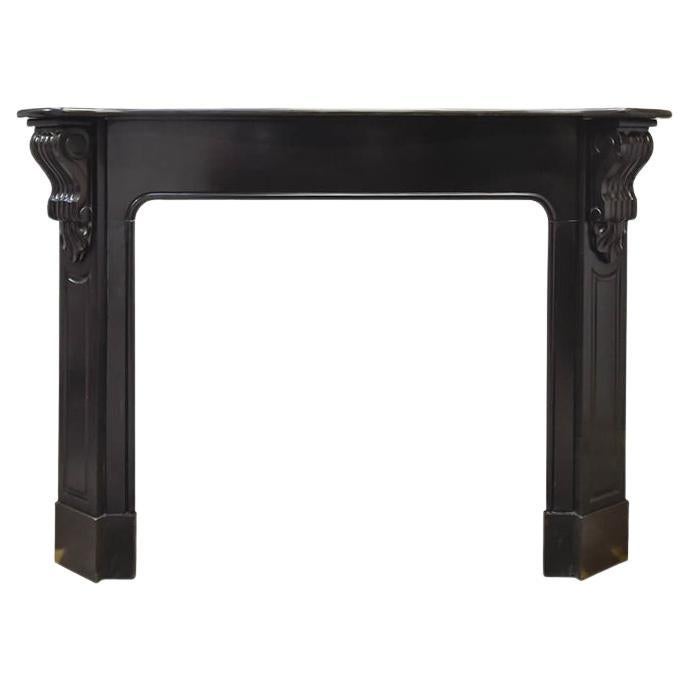 Cornice per camino a modiglioni in marmo nero del 19° secolo in vendita