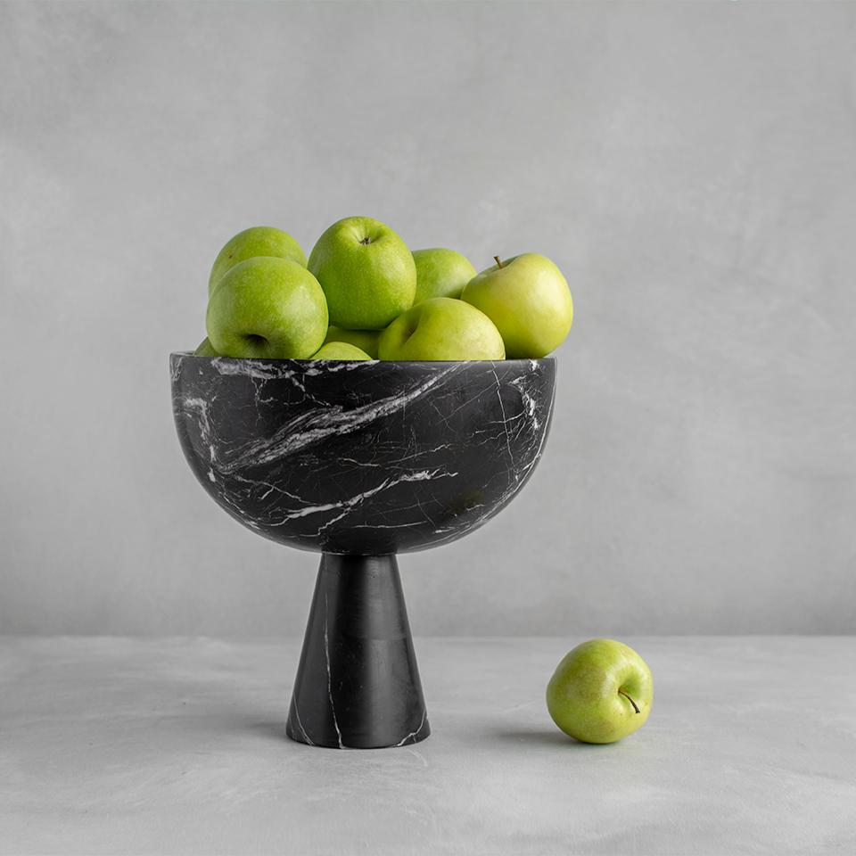 Eine große Schale aus schwarzem Marmor mit einzigartiger weißer Maserung ruht auf einem Sockel für die Präsentation von Obst und Gemüse. 

Die Säure von Zitrusfrüchten kann auf Marmor Flecken hinterlassen. Aufgrund der natürlichen Eigenschaften