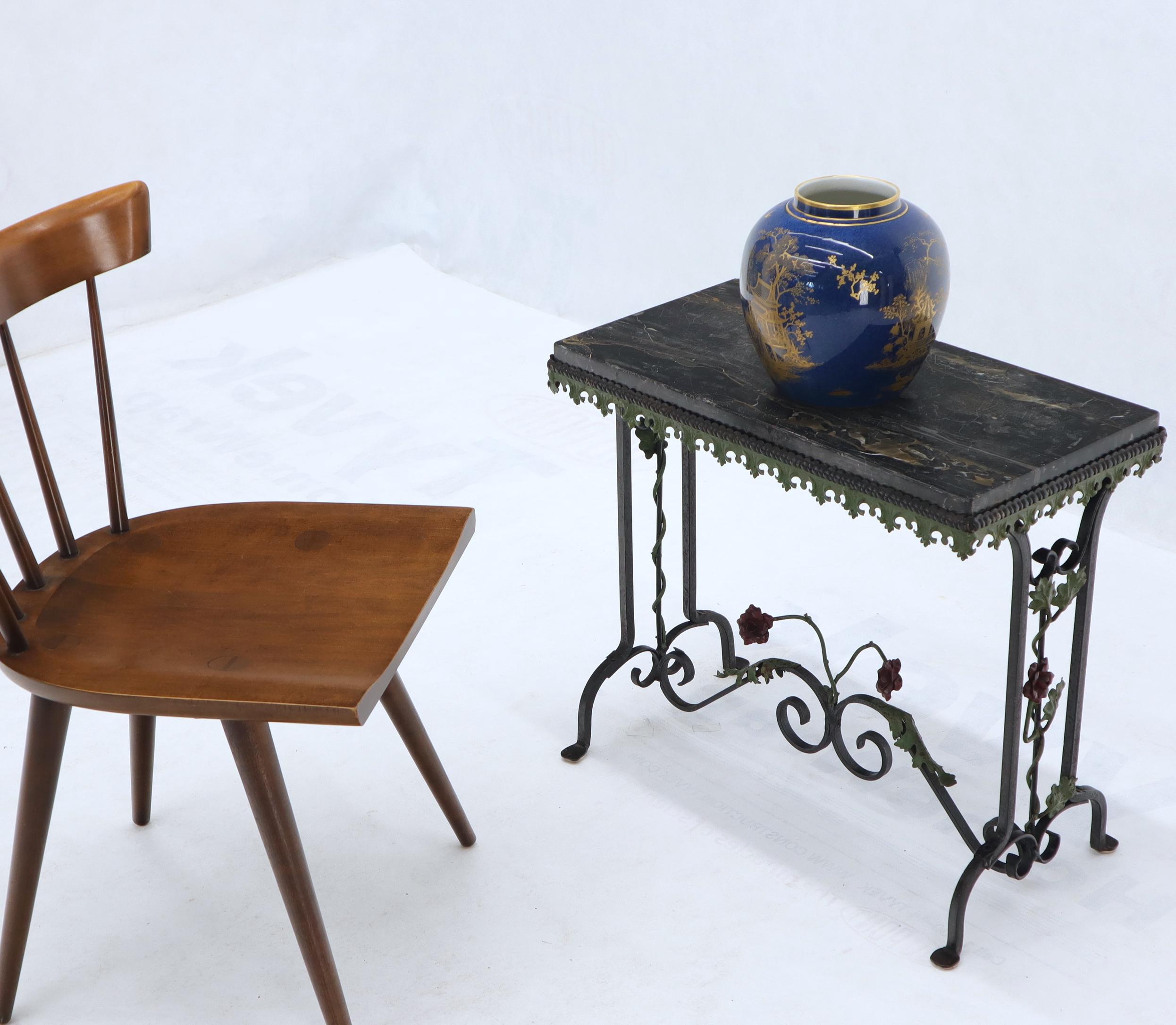 Wrought iron side table with thick black marble top. Decorated with forged metal roses.