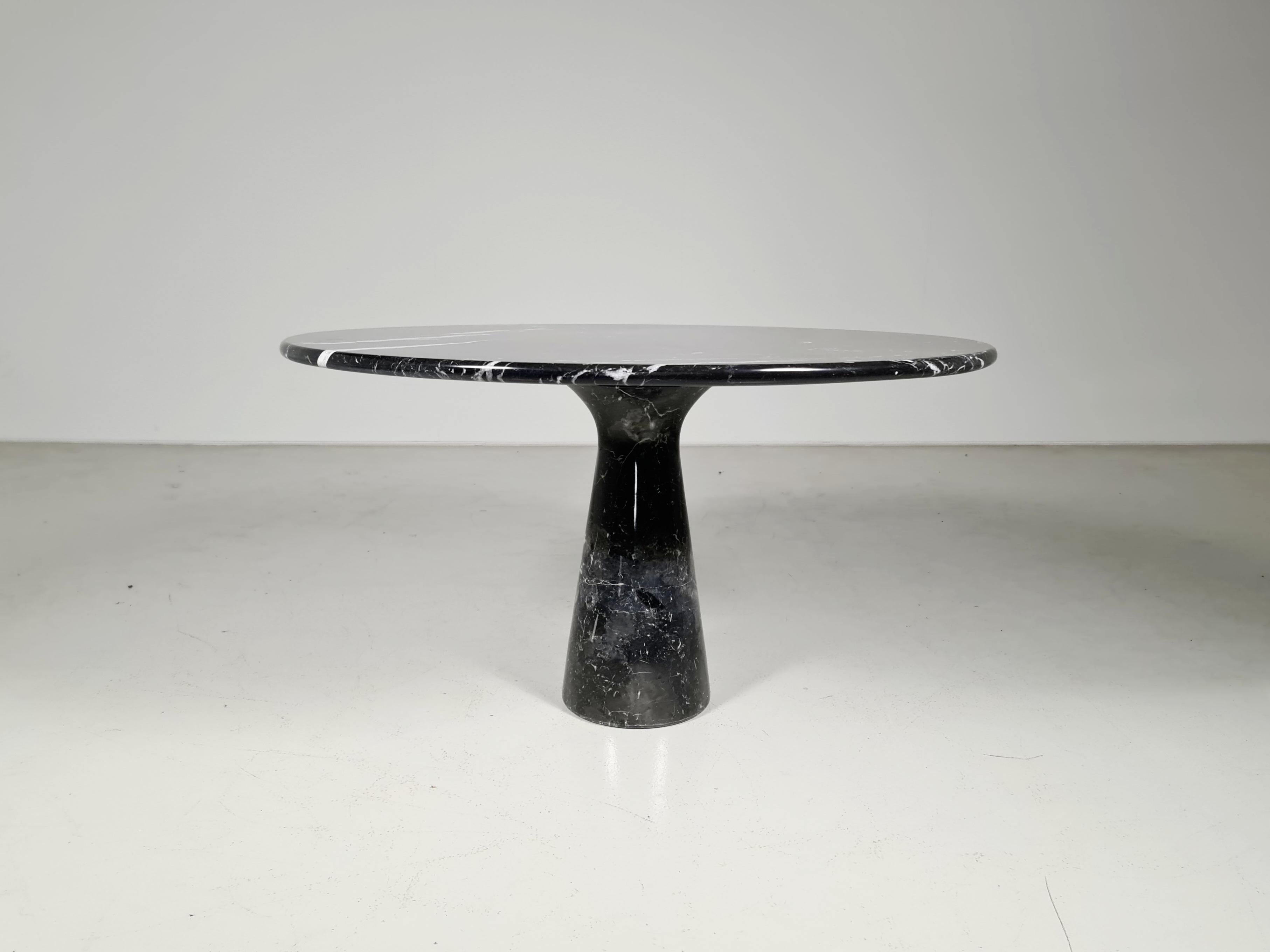 Black marble Italian dining table from the 1970s in the style of the Mangiarotti 'M1' dining table for Skipper. The cone-shaped pedestal rests on the round tabletop. The black marble shows a dynamic grain.
 