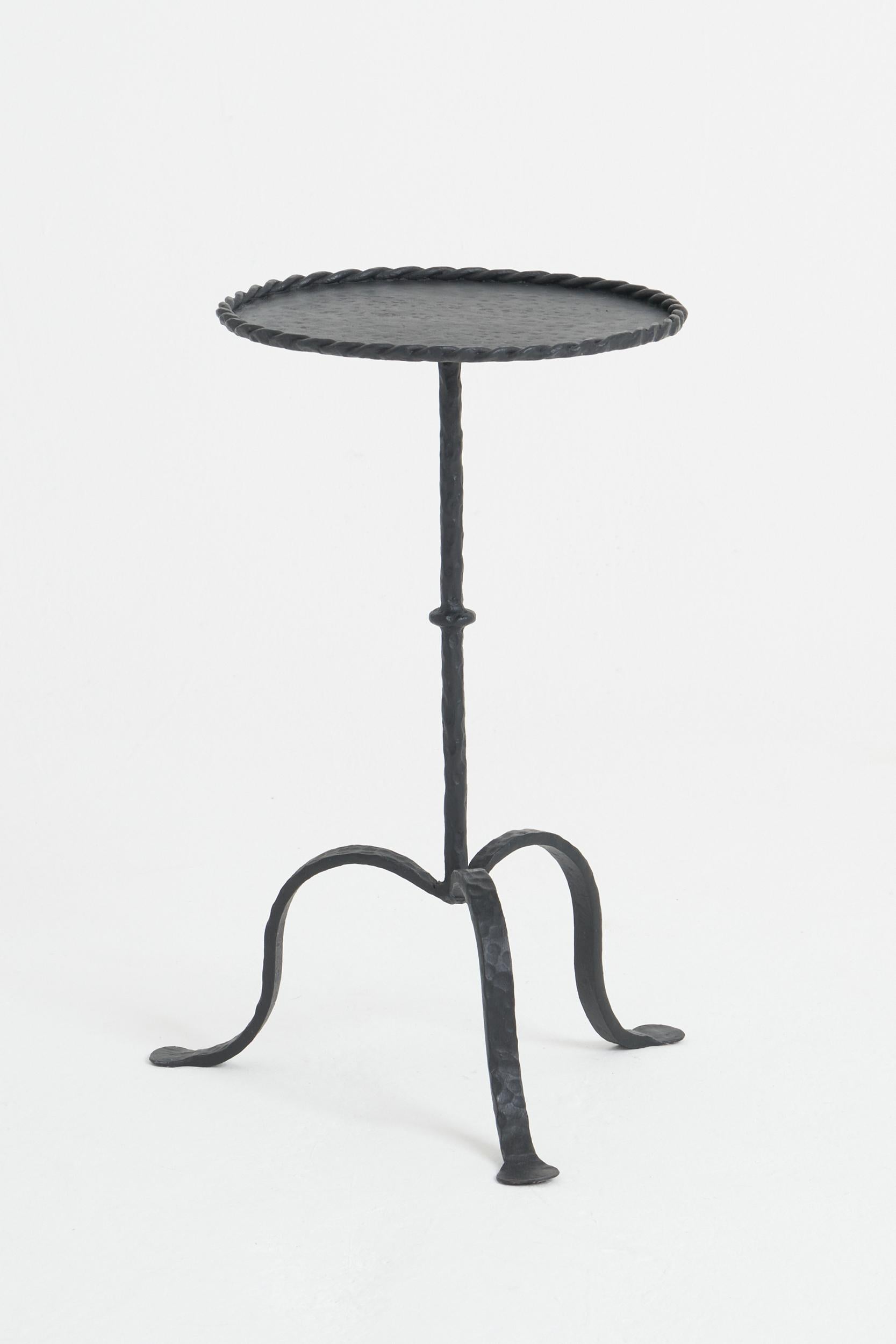 A black patinated wrought iron martini table, with a twisted rope edge.
Spain, Mid-20th Century
55 cm high by 32 cm diameter.