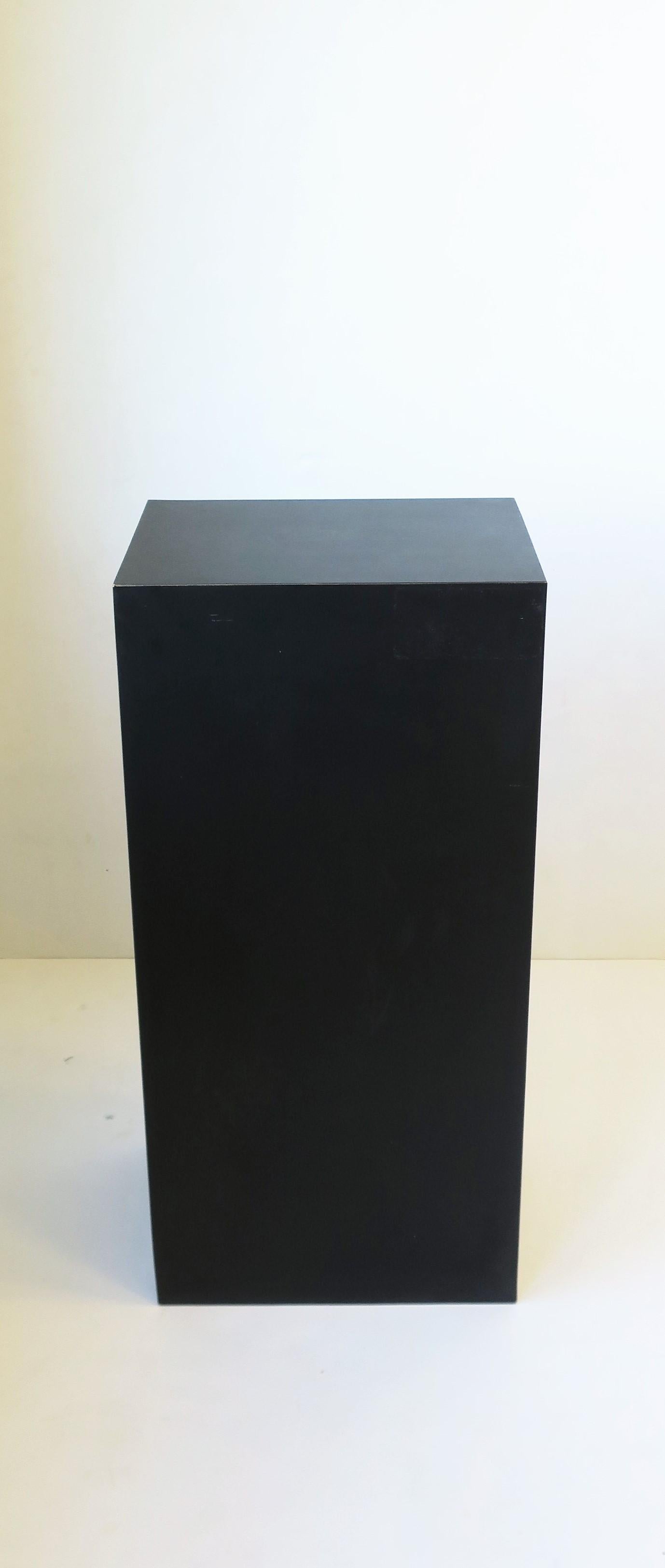 A '90s modern black rectangular matte laminate veneered pedestal column stand, circa late 20th century, 1990s. A great piece for sculpture, art, plant, display, end table, etc. Piece is rectangular, dimensions: 8.5