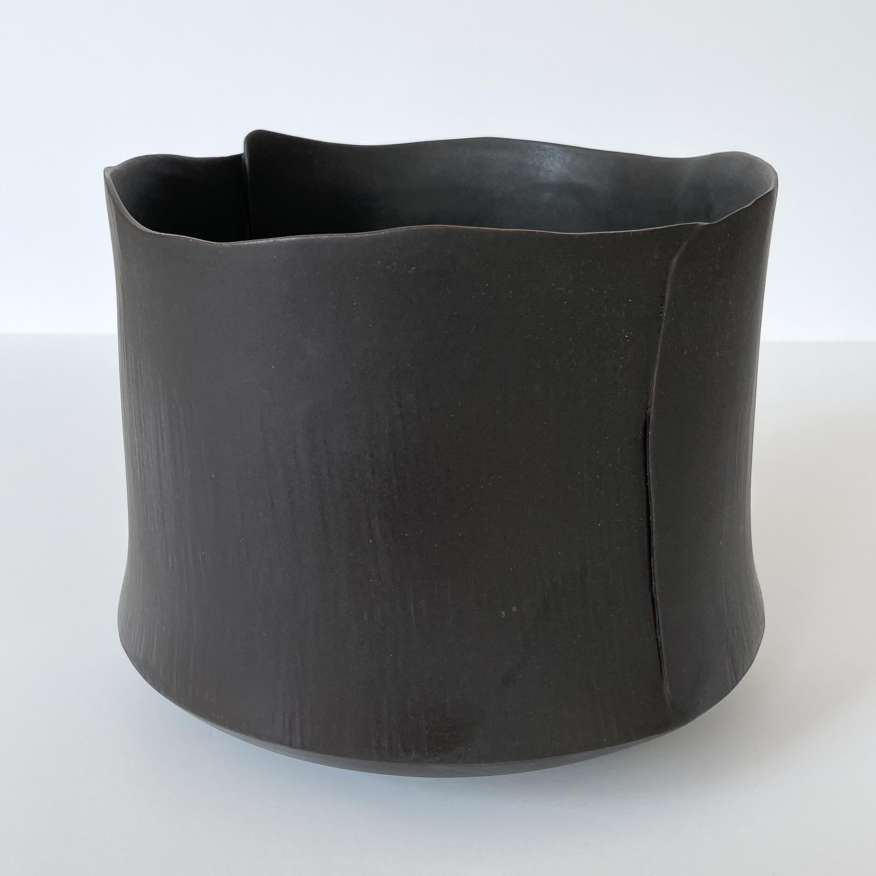 A large matte black glazed earthenware bowl by a North Carolina artisan. Minimalist and modern in form. Measures: 8.5