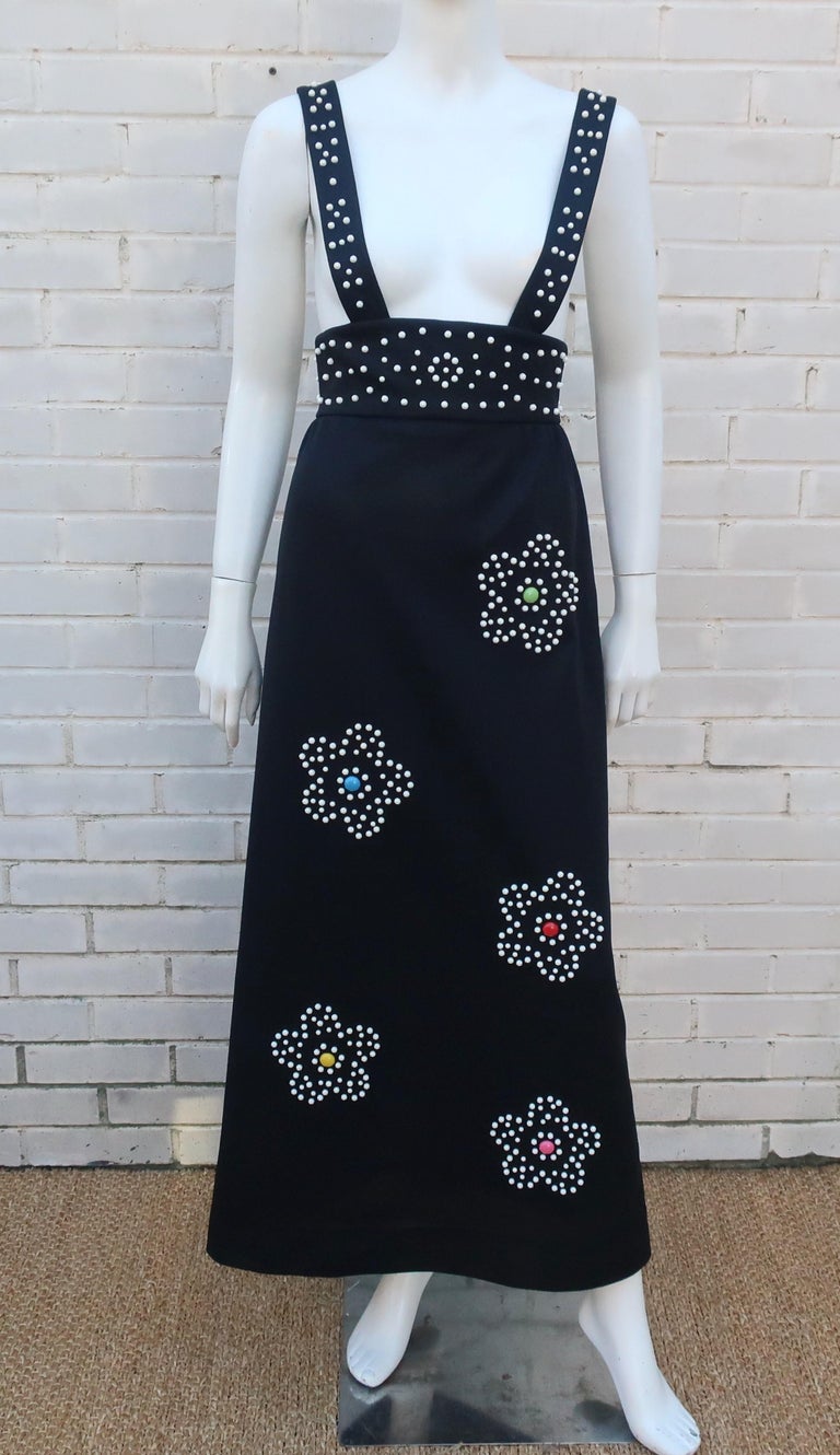 Flower power!  1960's black maxi jumper dress with an array of mod flowers in white faceted metal studs accented by colorful centers in shades of hot pink, red, green, yellow and blue.  The dress zips at the back with crisscrossed straps.  The