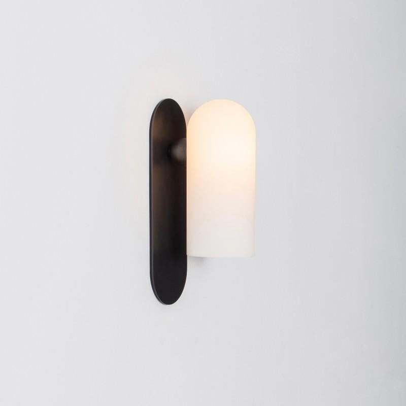 Black medium sconce by Schwung
Dimensions: W 10.5 x D 14 x H 30.5 cm
Materials: Black gunmetal, frosted glass

Finishes available: Black gunmetal, polished nickel, brass


Schwung is a German word, and loosely defined, means energy or momentumm of a