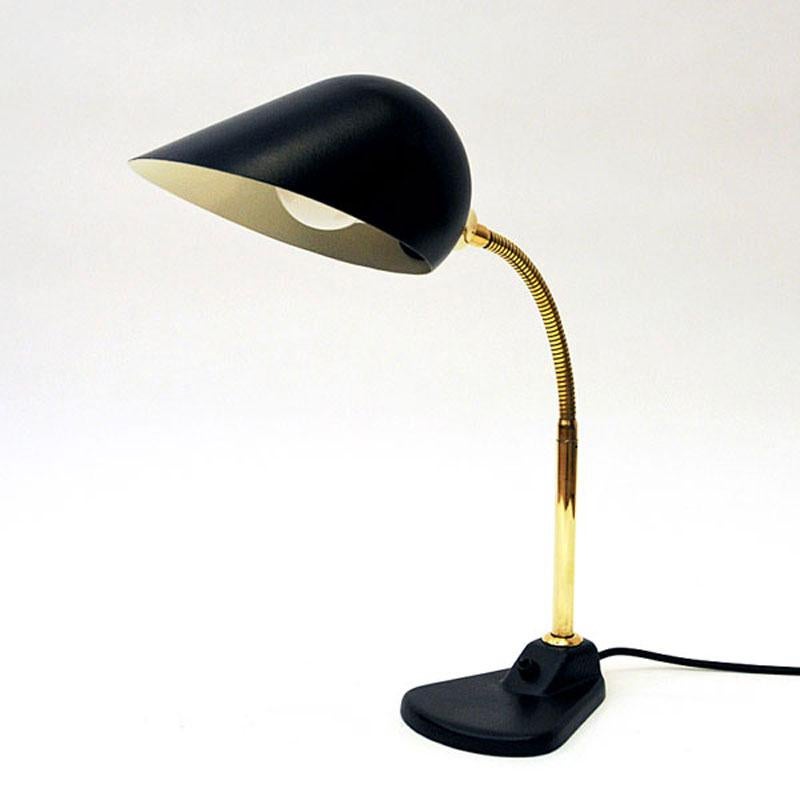 Metal and brass tablelamp with adjustable gooseneck head in which can be moved in all directions. Lovely design and shape. Beautiful beakshaped metal shade with white inner color. Brass body and black matching cord and the light switch located on