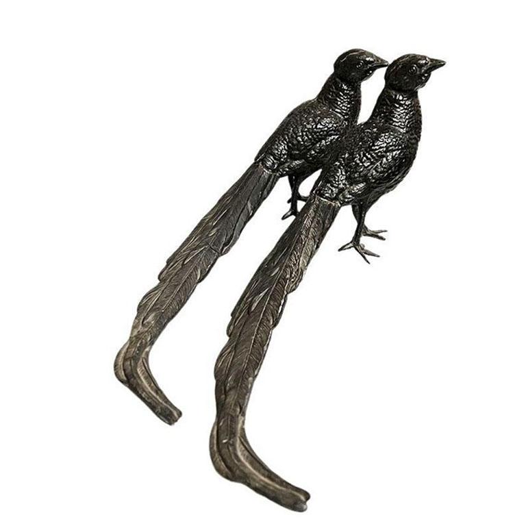 Pair of large cast-iron metal pheasant birds in black. Each figure is identical and features a pheasant with its long tail, textured to resemble feathers. This would be a wonderful pair to place on a bookshelf. This set is by CCK Co. New York,