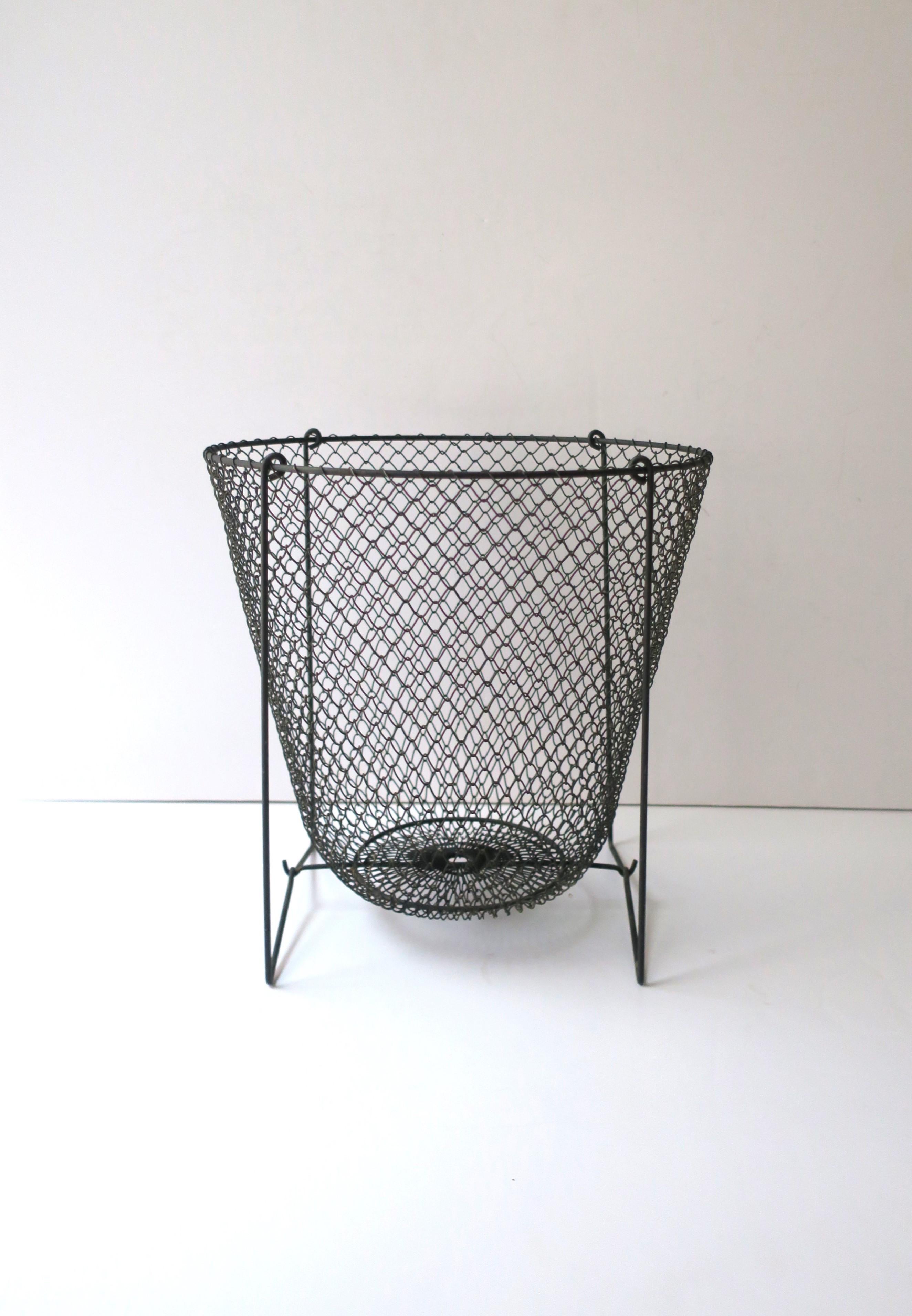 A black wire metal mesh wastebasket trash can, circa late 20th century. In the Midcentury Modern Industrial style. Very good condition as shown in images. Dimensions: 11.75