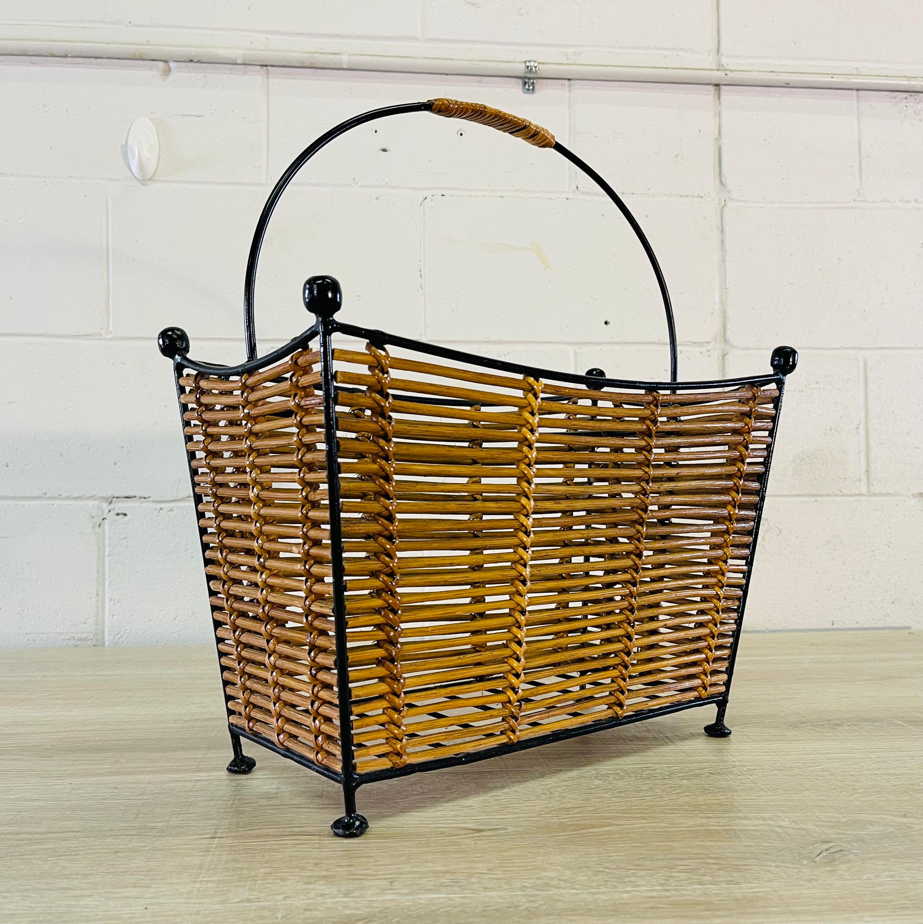 Vintage black metal and rattan two-part handled magazine rack. The handle is also wrapped with rattan. No marks.