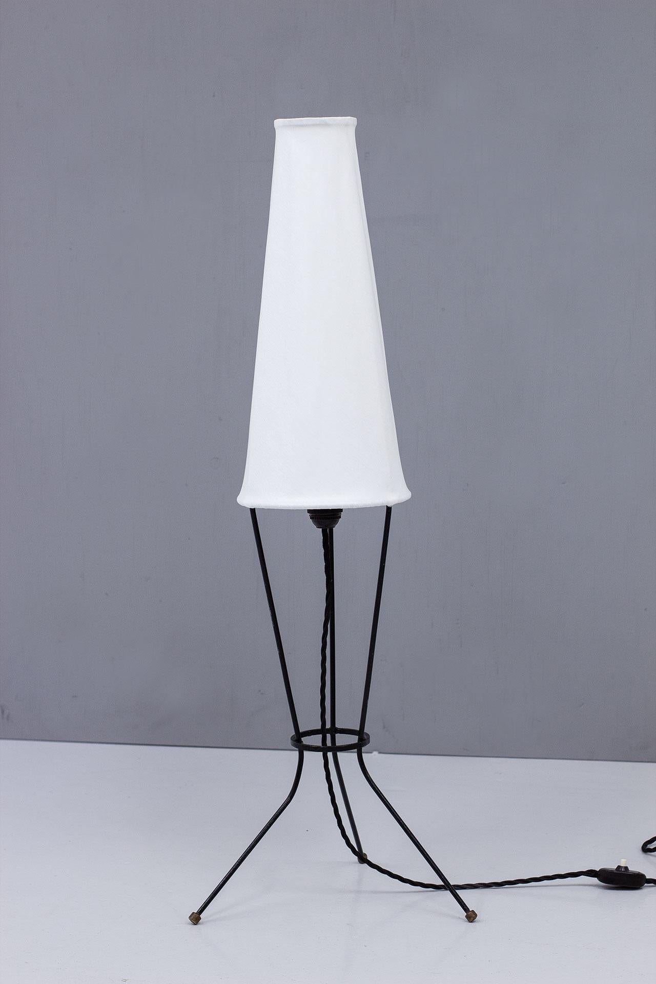 A Swedish Modern Floor / Table Lamp with a height that is in between.
Features a black lacquered metal frame with a newly reupholstered off-white chintz fabric screen. Brass foot enders.
New electricity with a light switch on the chord in working