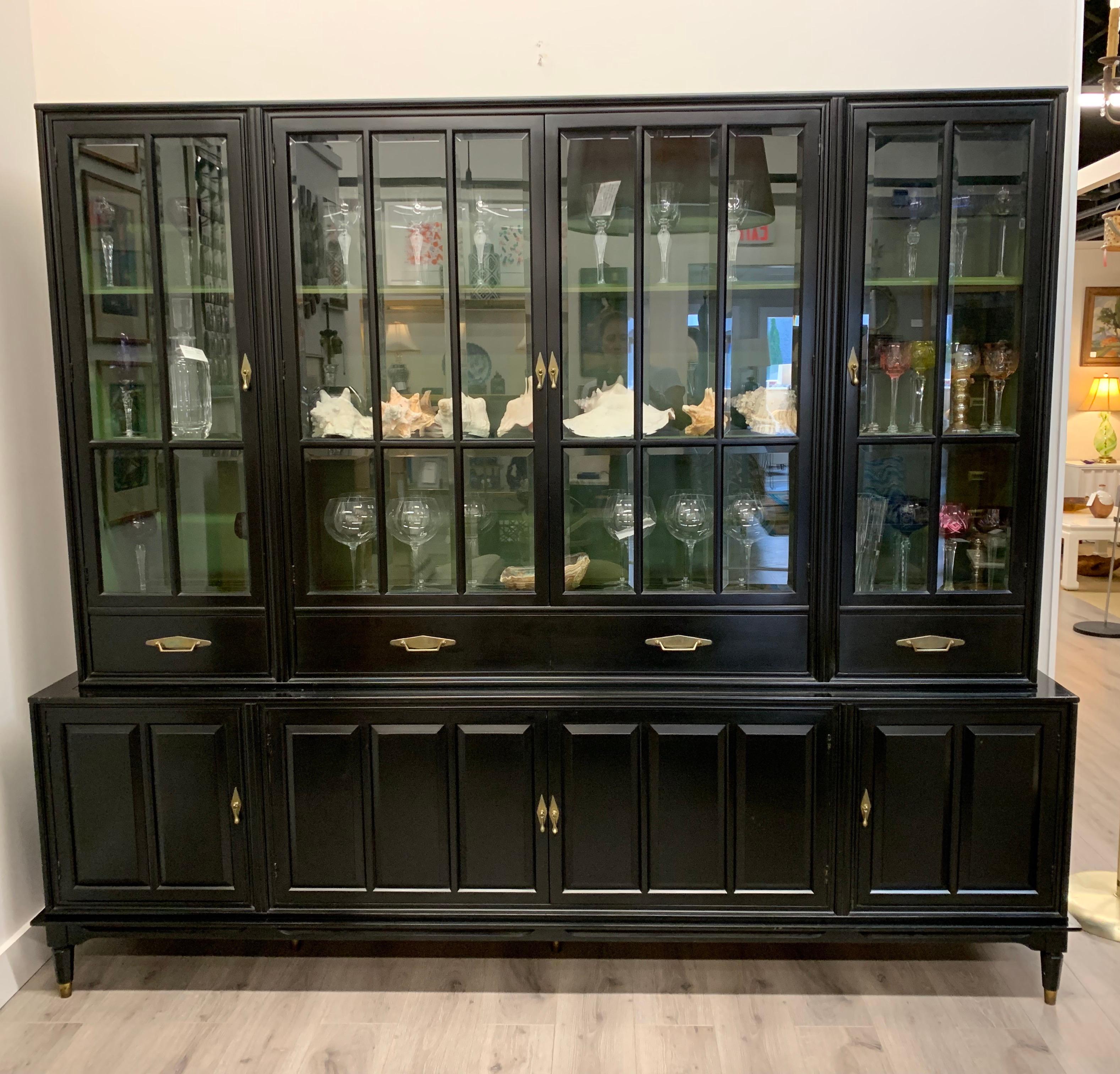 Elegant large black 1950s display cabinet which features a black and glass exterior as well as green hand painted interior shelving, three levels. It comes in two pieces, a top and bottom.