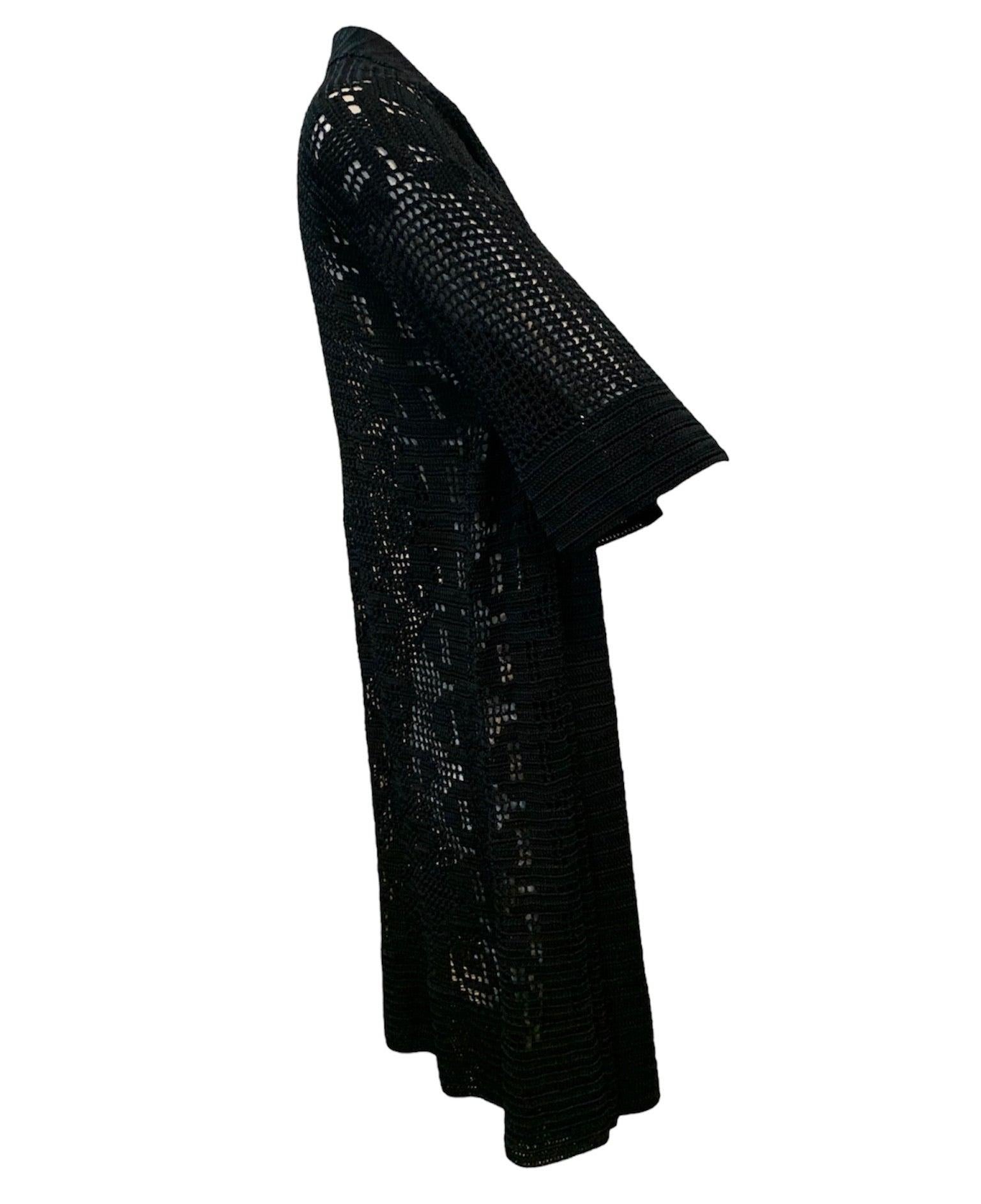 A lovely, rare piece from the 1920s. Hand crocheted open front knee length cardigan in inky black. Accompanied by matching self tie sash belt with dangling balls. Art deco motif with 3/4 sleeves. For the casual flapper. Excellent condition. Sizing