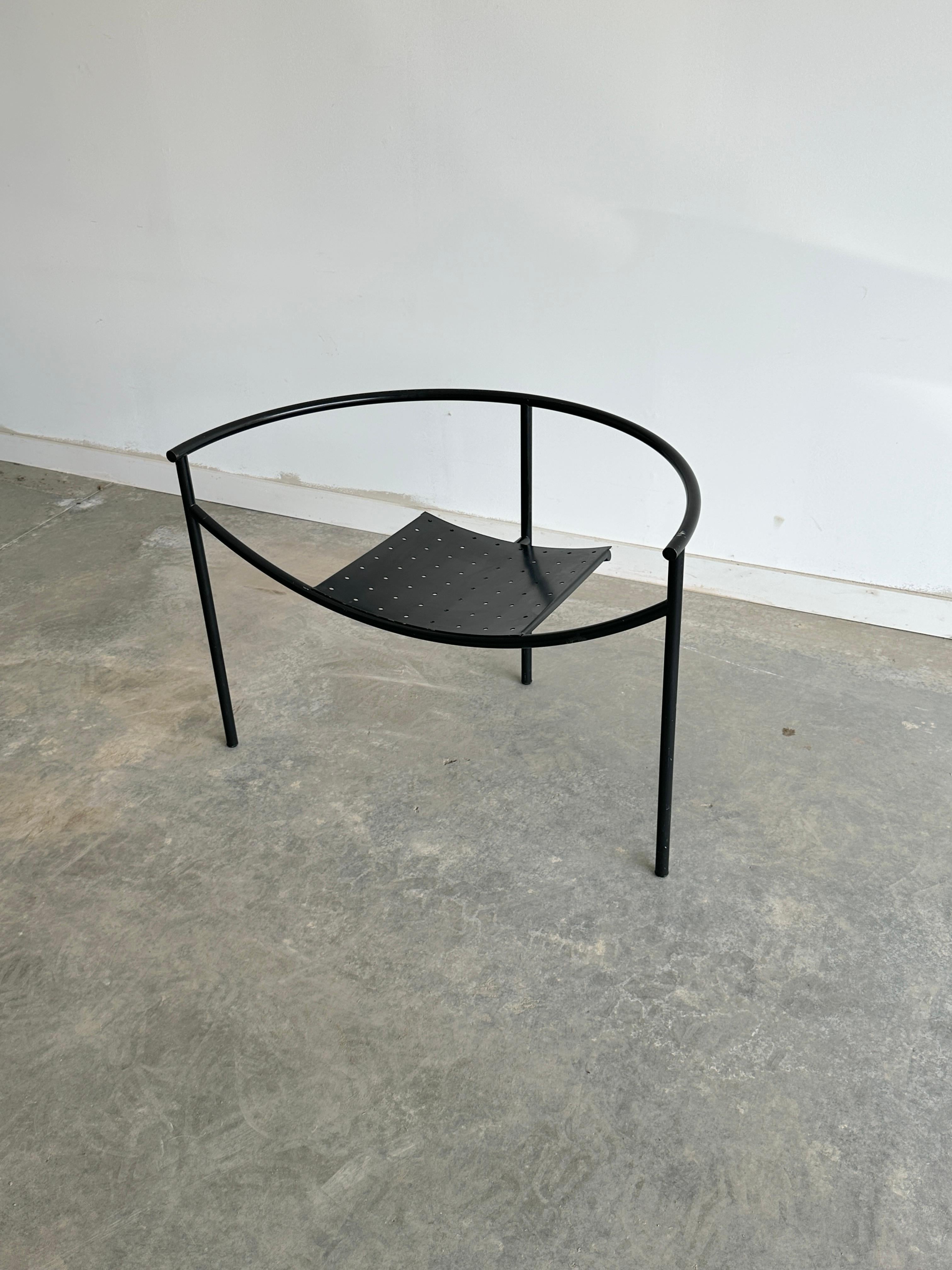 La chaise Philippe Starck Doctor Sonderbar est un meuble saisissant qui allie un design futuriste à une esthétique industrielle. Il est composé de tubes en acier chromé et de tôle perforée, créant une silhouette épurée et sculpturale. La chaise a