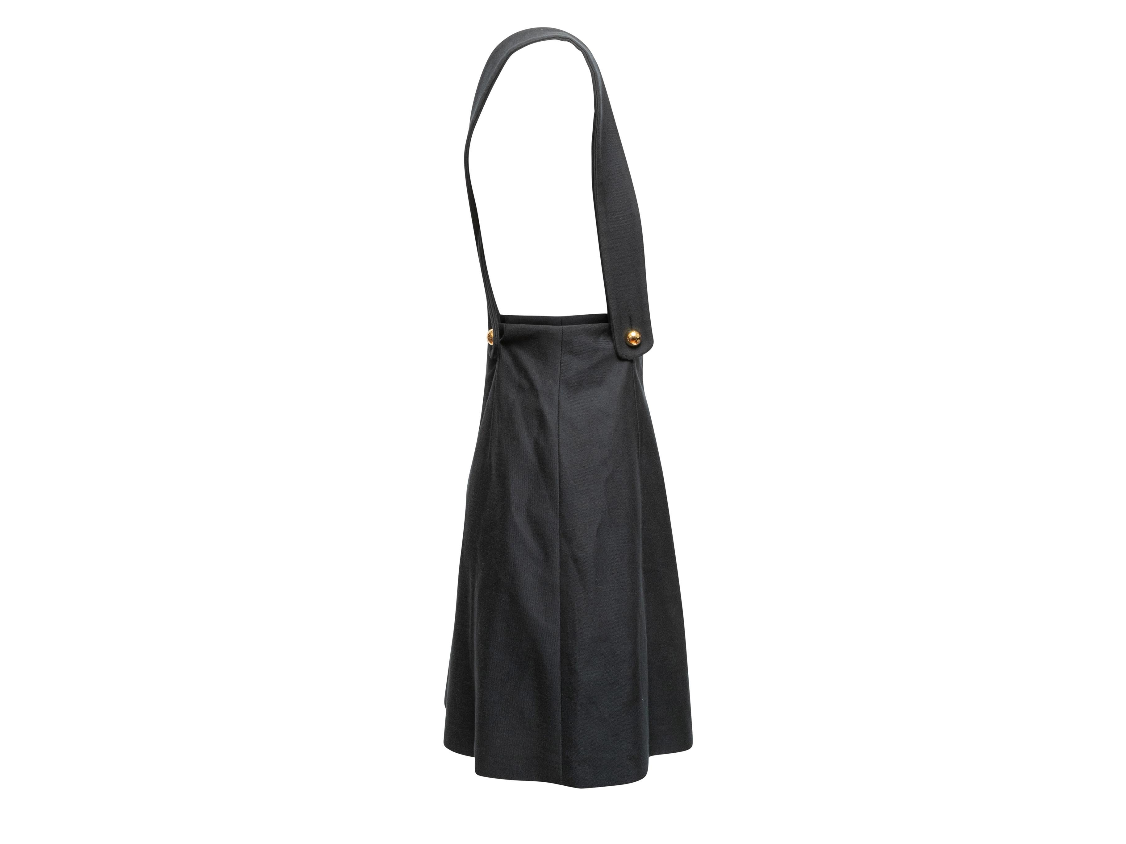 Black suspender mini skirt by Miu Miu. Dual shoulder straps. Button closures at waist. 27