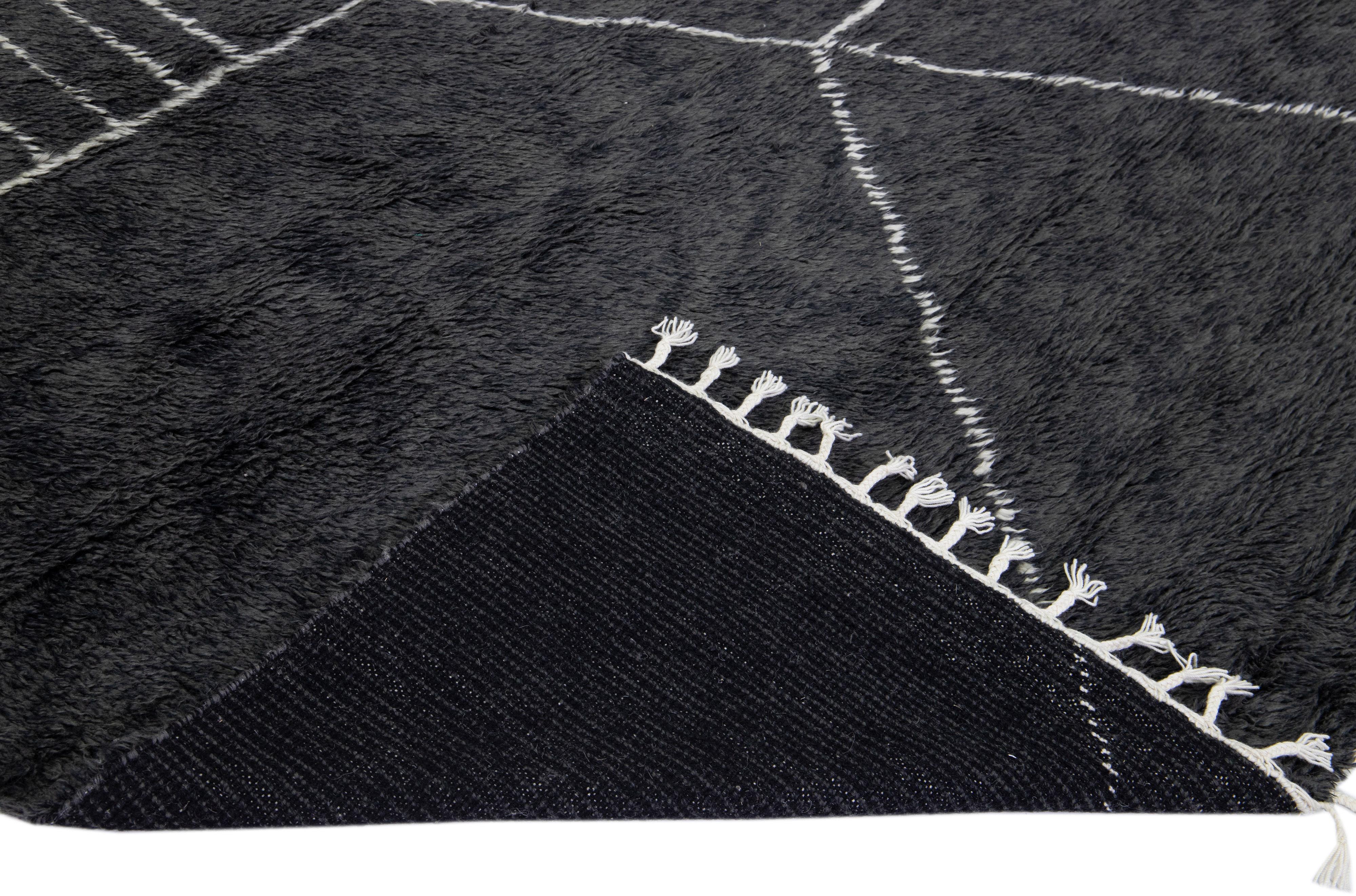 Beautiful modern Moroccan style hand-knotted wool rug with a black field and white fringes in a gorgeous geometric abstract high pile design.

This rug measures: 10'6'' x 13'10''.

Our rugs are professional cleaning before shipping.
