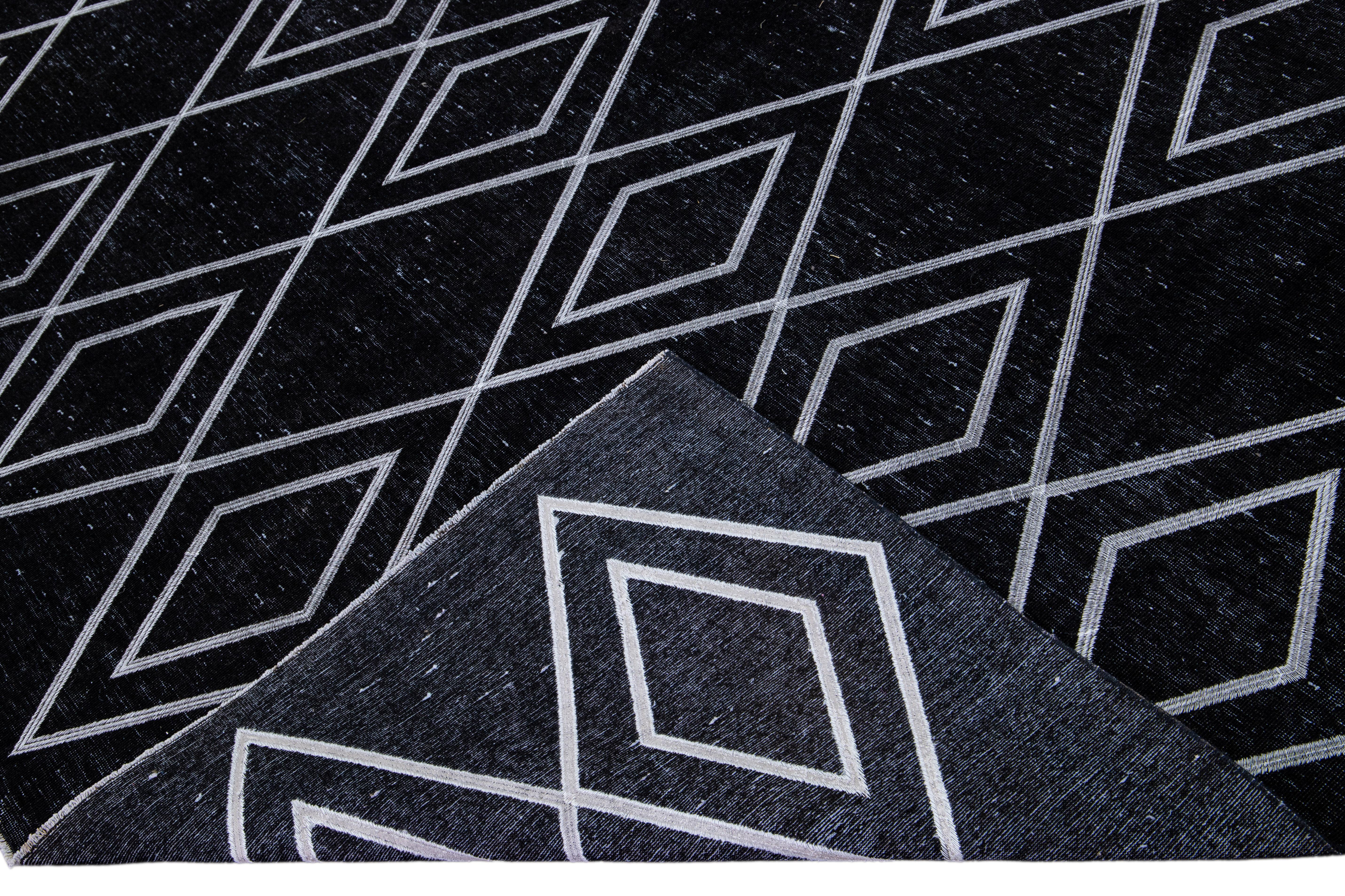 Beautiful Turkish handmade wool rug with a black distress look field. This Modern rug has white accents featuring a gorgeous all-over geometric diamond pattern design.

This rug measures: 9'3
