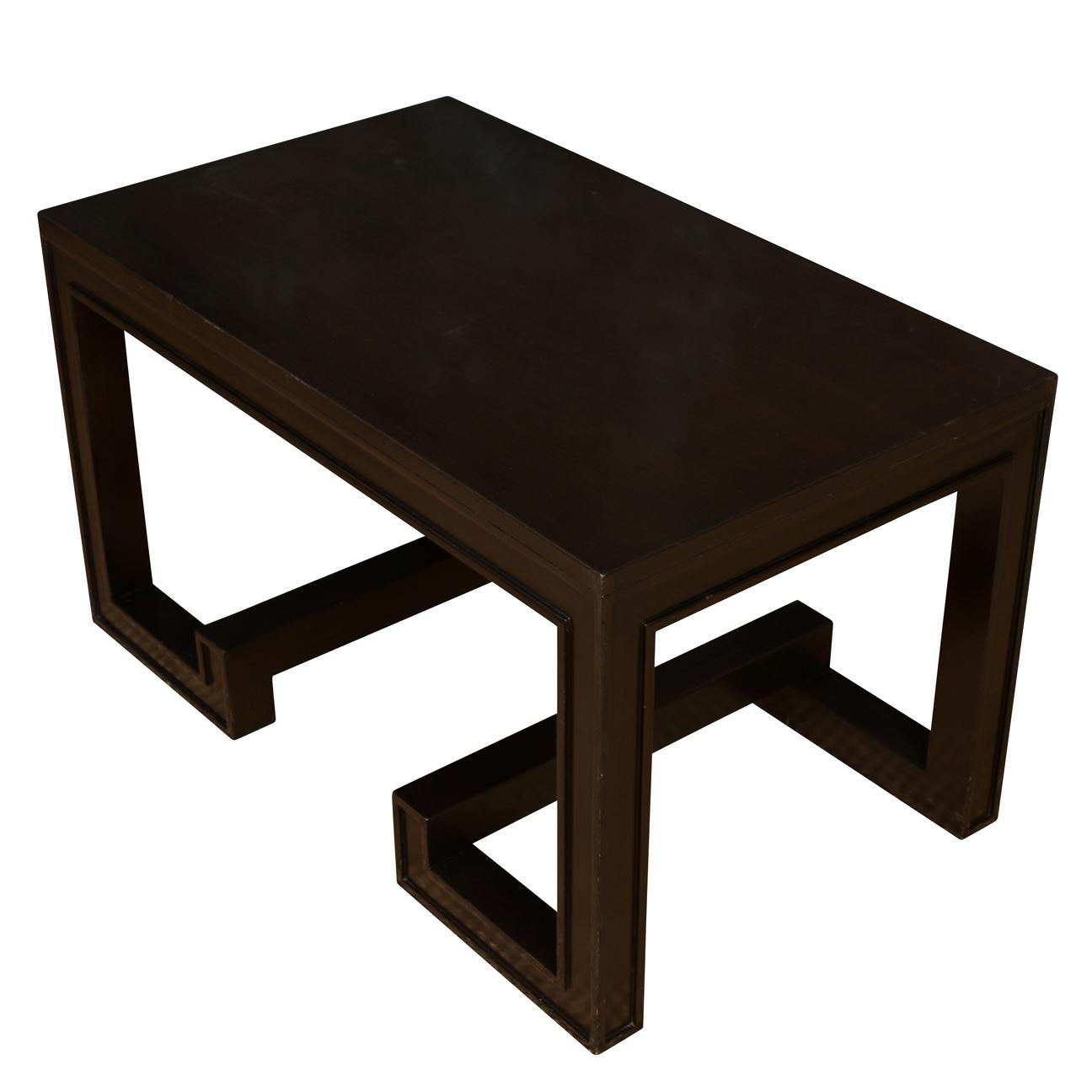 A deep chocolate brown painted modernist coffee table with an angular base.