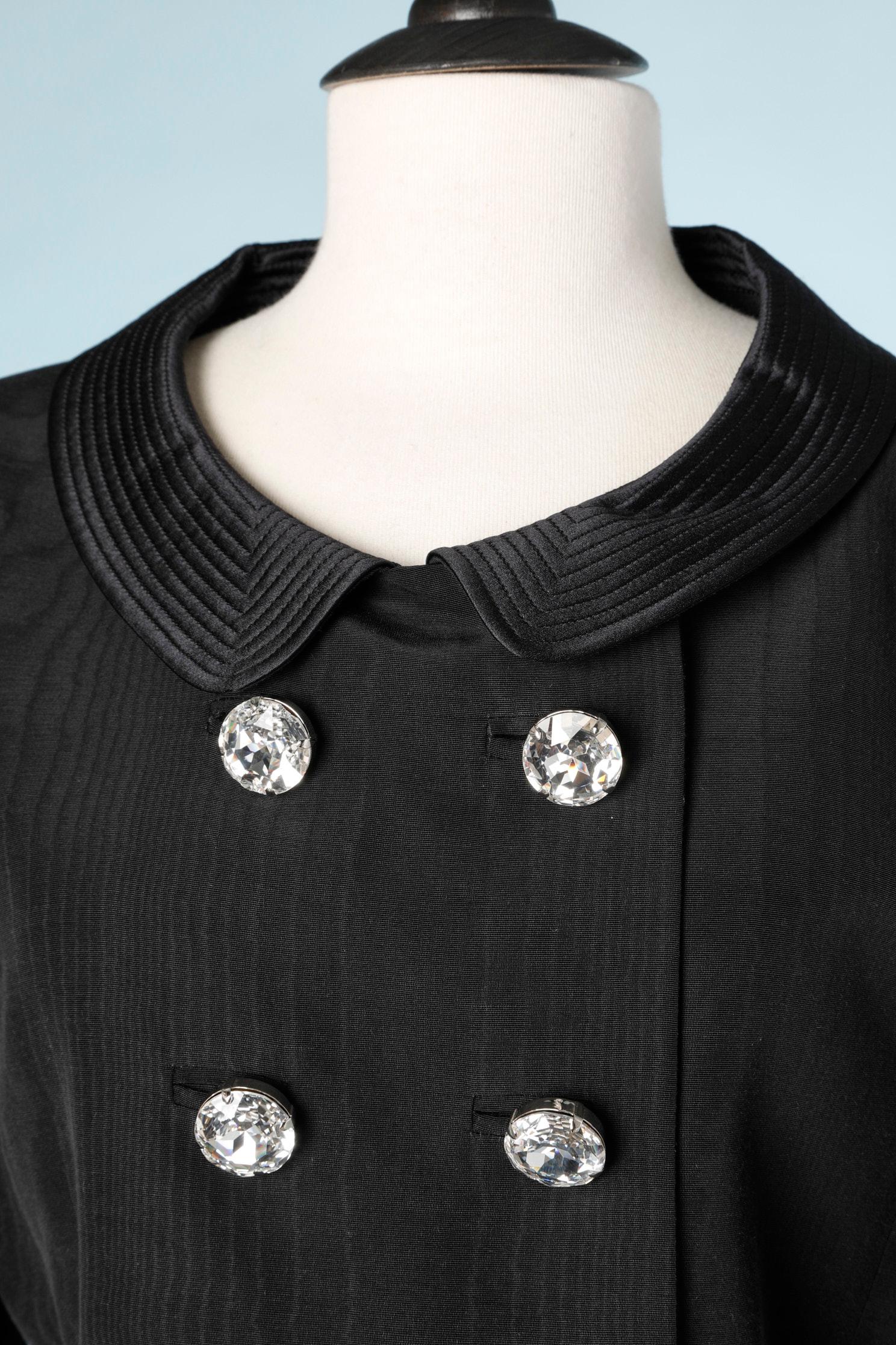 Black Moiré evening skirt-suit with rhinestone buttons and top-stitched collar. 
Main fabric composition: 54% rayon, 46% cotton. Top-stitched Claudine collar. Lining composition: 64% acetate, 36% rayon. 
Shoulder pad. 
SIZE L