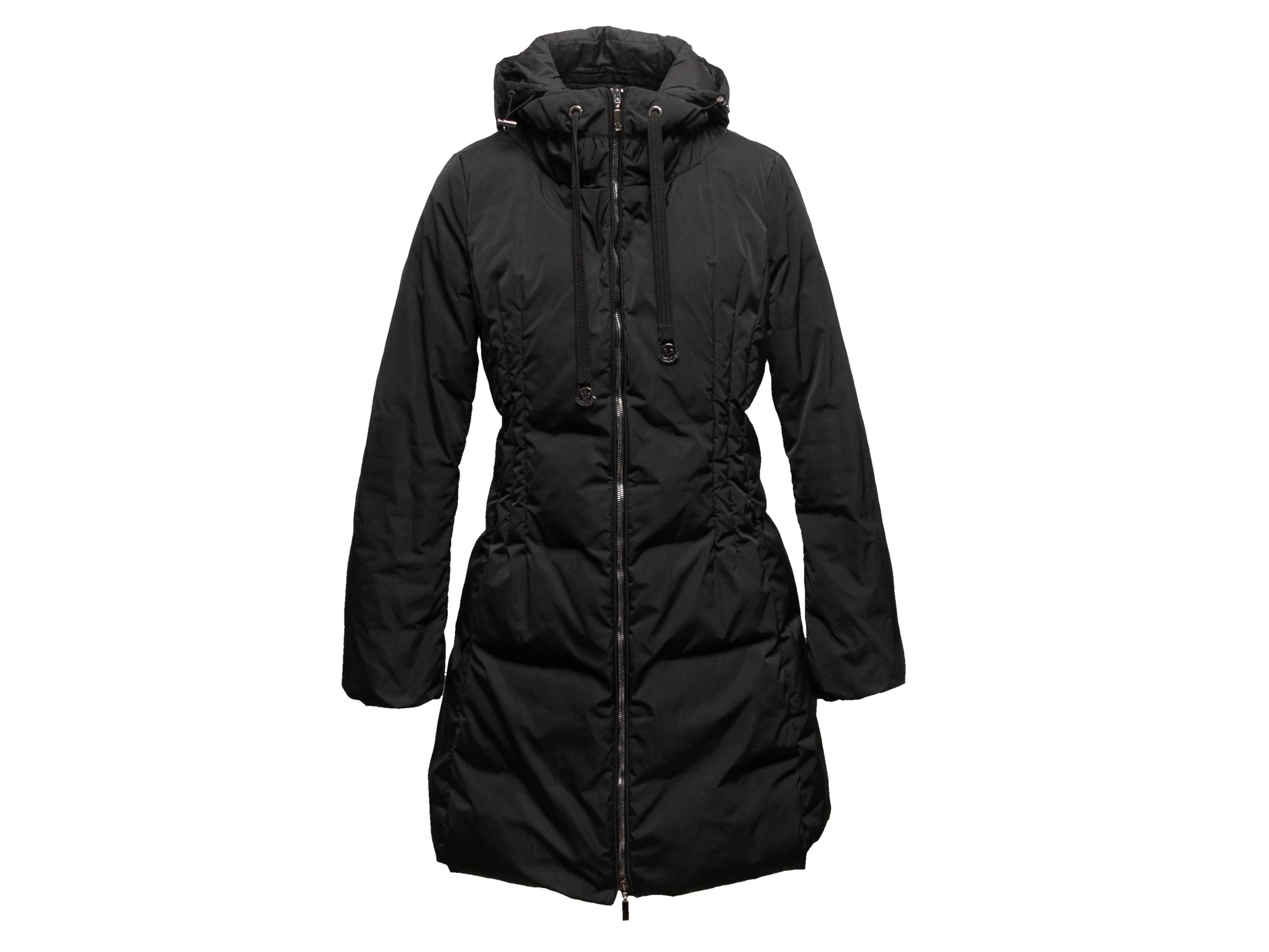 Black hooded down puffer coat by Moncler. Drawstring at hood. Zip closure at center front. 36