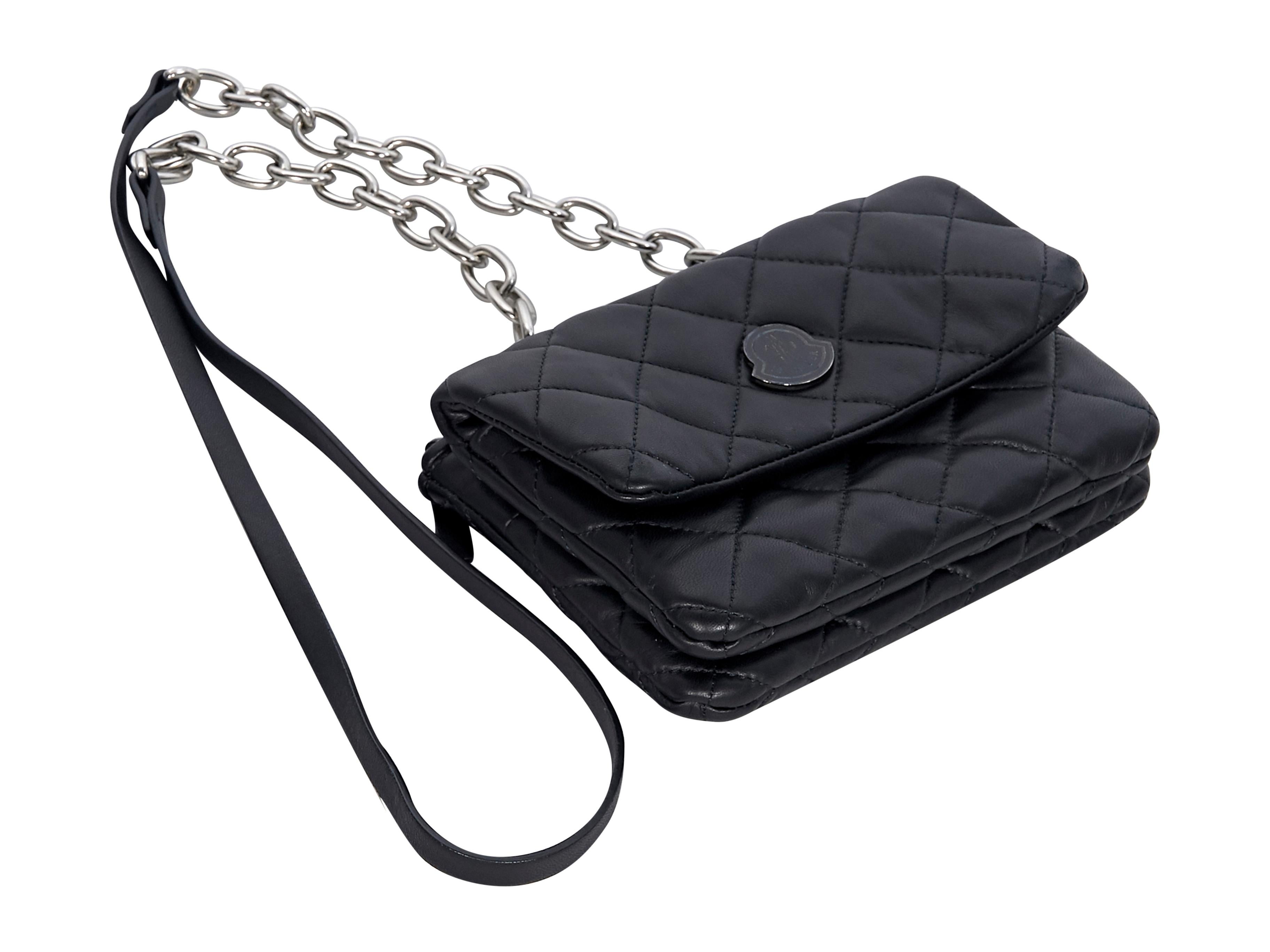 Product details: Black leather quilted crossbody bag by Moncler. Single chain and leather shoulder straps.  Front flap with snap button closure. Lined interior. Top zip closure. Back exterior zip compartment with inner zip pocket. Silver-tone