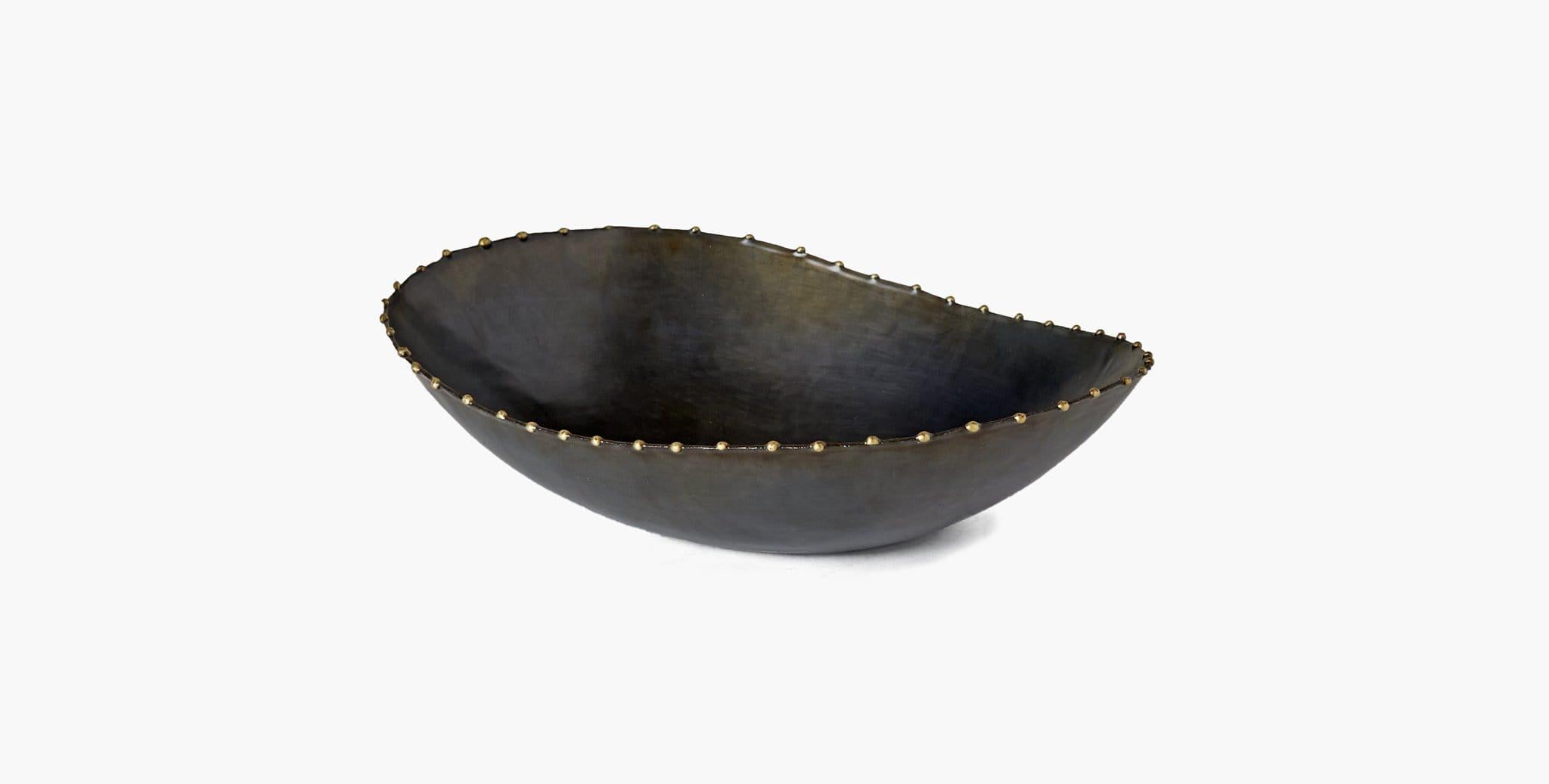 Our Montana Bowls effortlessly elevate your home décor, featuring organic curves in ebonized iron with subtle metal detailing to highlight its serpentine edge. Our handcrafted finishes are inspired by variations within natural textures. Each