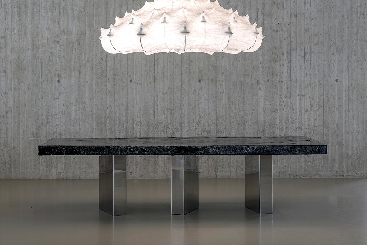 Cette table unique en son genre est fabriquée à partir de bois naturellement corrodé et sculpté par le feu, sélectionné pour ses textures organiques distinctives et ses irrégularités structurelles. La surface a été méticuleusement stabilisée par de