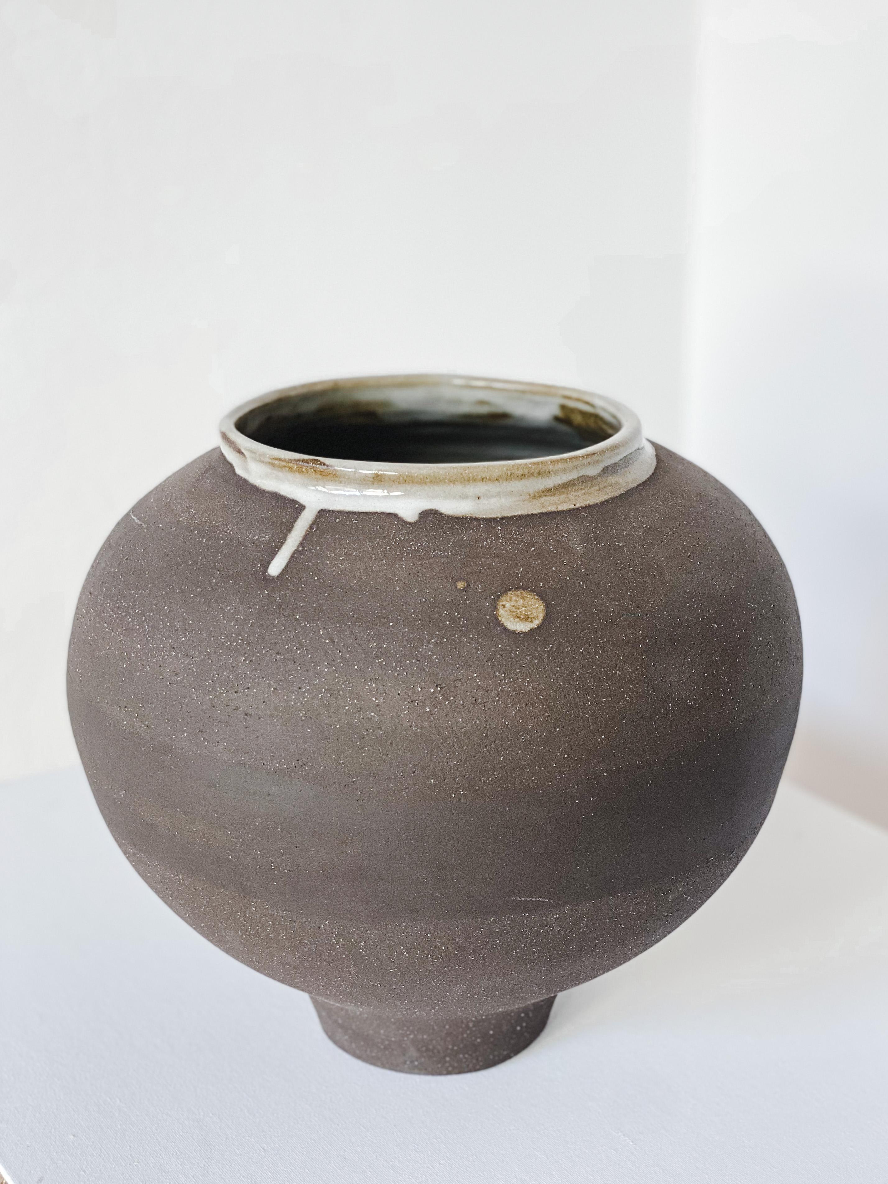 Black moon vase by Arina Antonova, 2021
Dimensions: H 30 x D 30 cm
Materials: stoneware, porcelain, wild clay.

Born in Sewastopol (Crimea), I was surrounded by the natural variety of the coastal Black Sea views with rocky beaches and