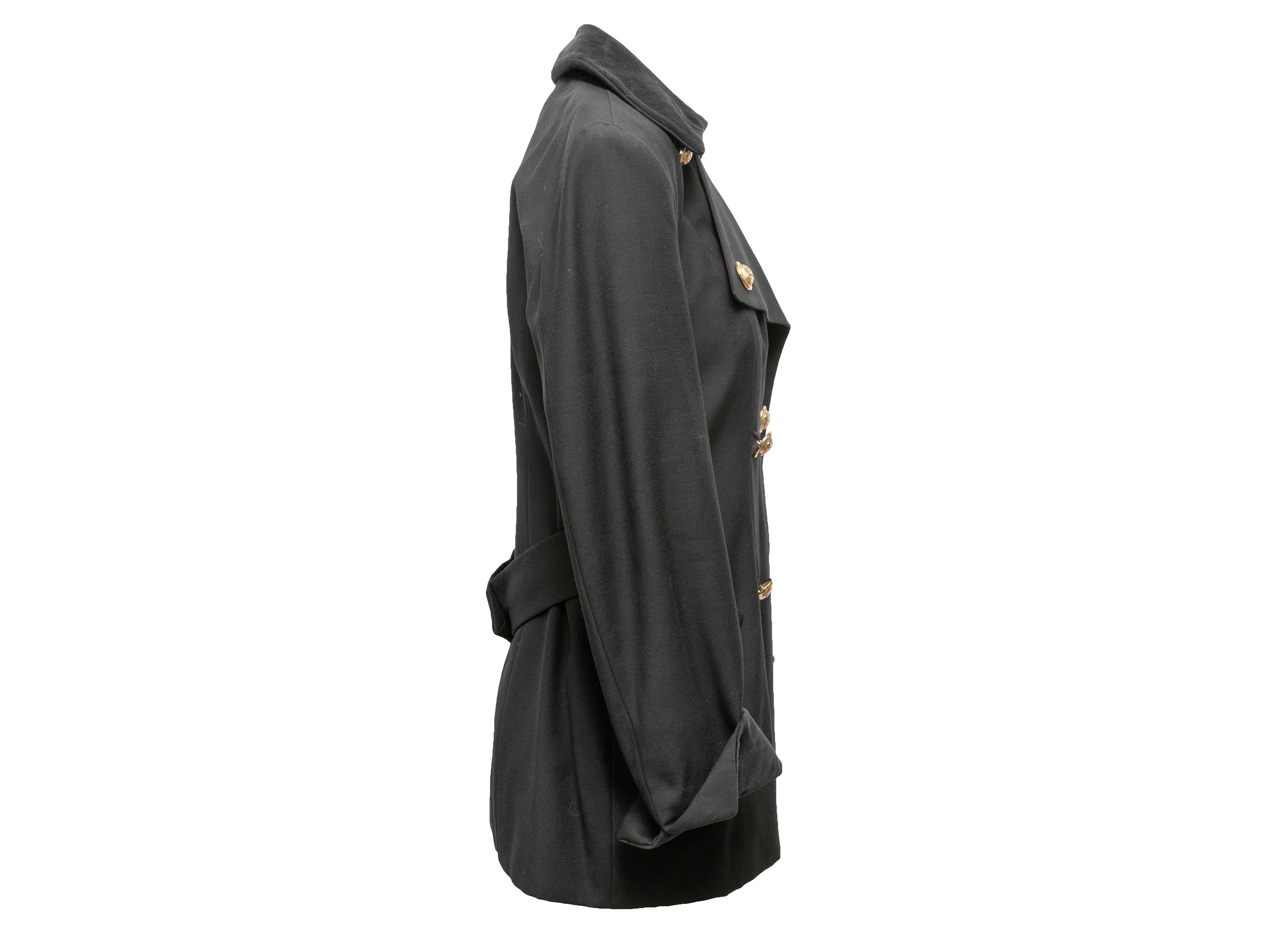 Cappotto doppiopetto in lana nera di Moschino Cheap and Chic. Colletto a punta in velluto. Doppie tasche sui fianchi. Chiusura con bottoni dorati sul davanti. Busto 33