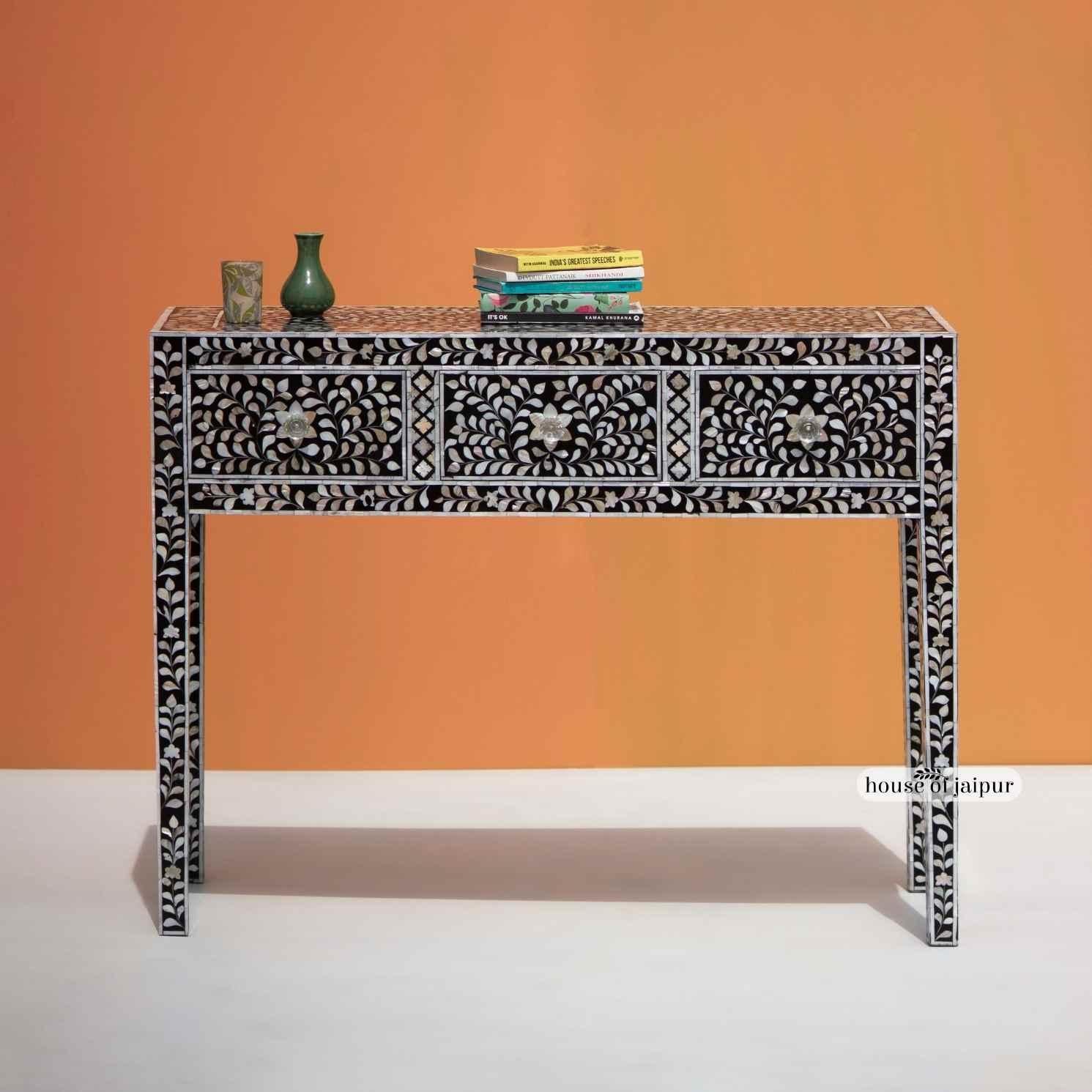 Designed to bring a touch of elegance and artistry into any interior, this Mother of Pearl Inlay Console Table features a rich black base adorned with a detailed floral vine pattern. Each iridescent MOP piece is individually hand-cut and carefully