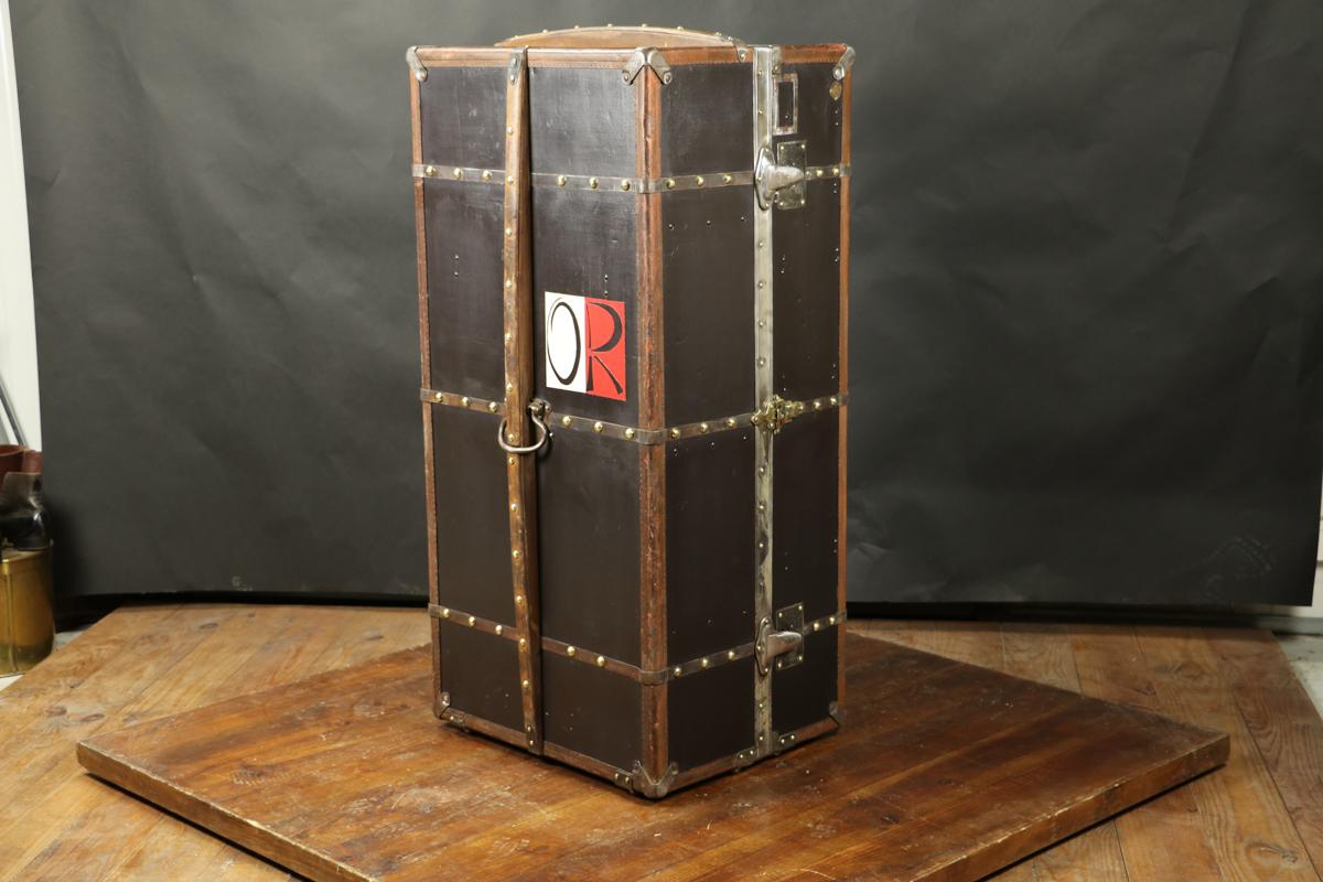 Black Moynat wardrobe trunk from 1917 
Outside remade 
Original inside 
Original wooden hangers 
This model also allows the use of modern hangers. 
The curved slats on the sides and on the top made it possible not to transport or place the